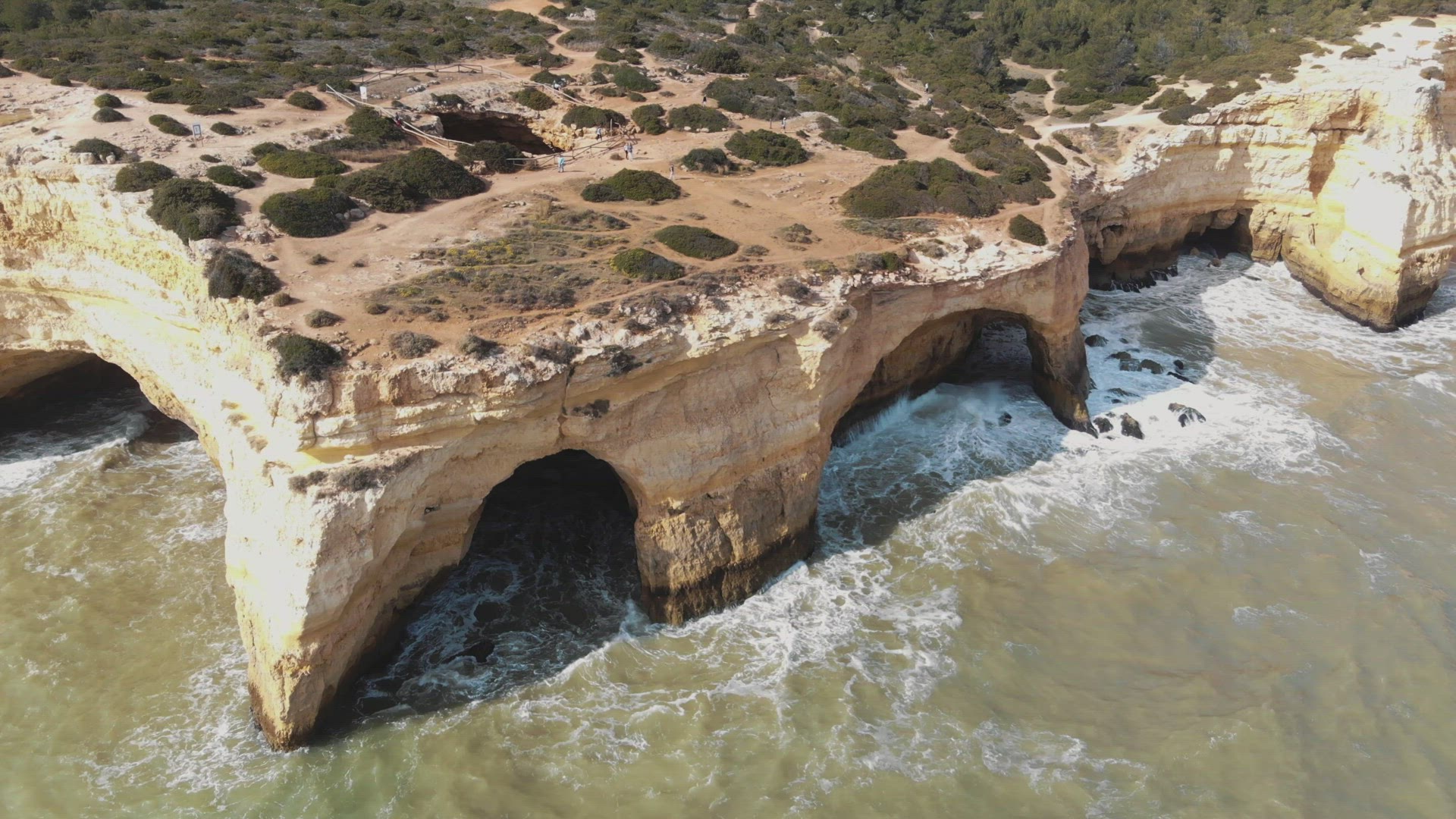 4k aerial drone footage circling a unique rock formation found along the shoreline near the coastal 