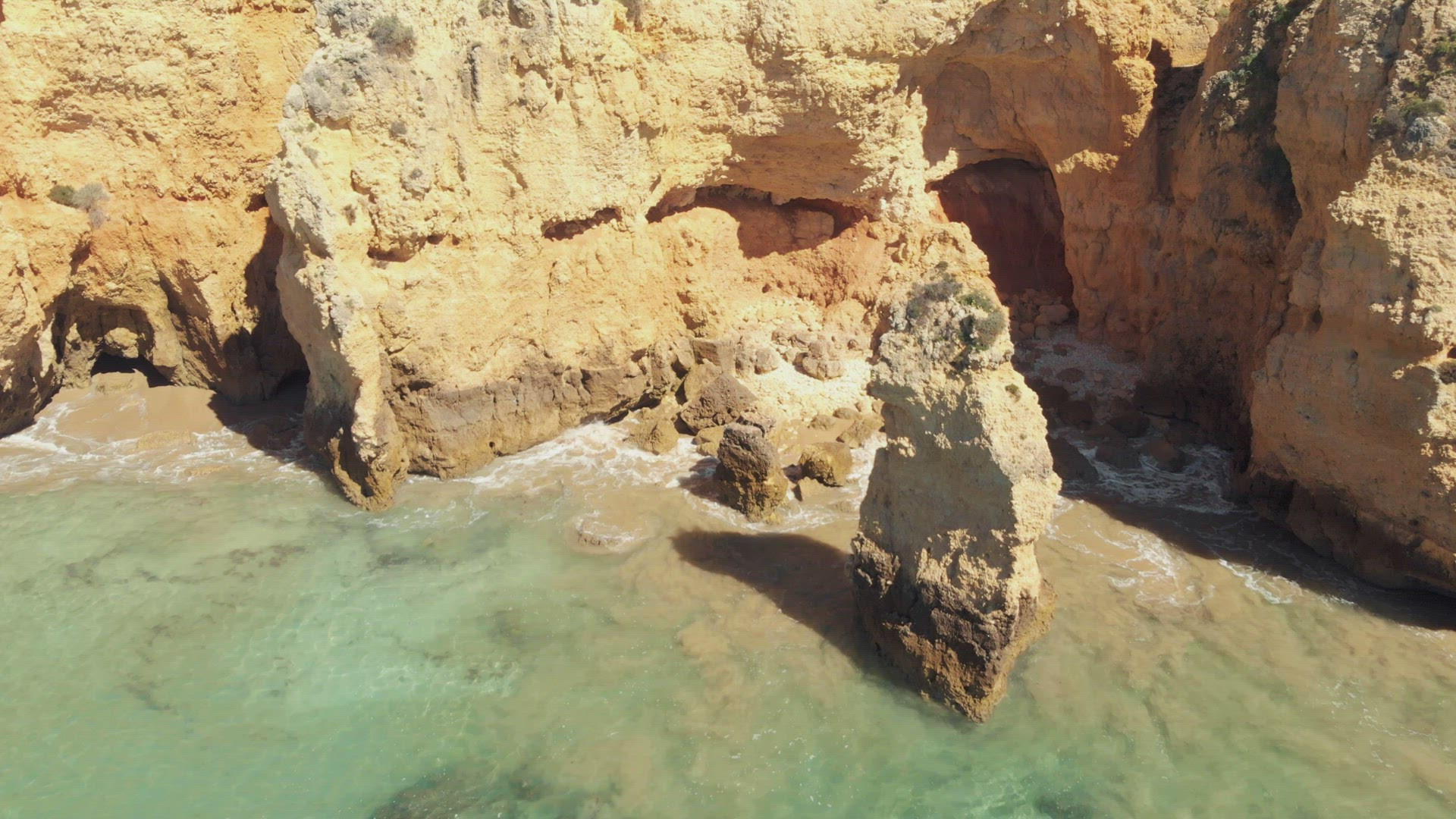 Cliffs and caves of pristine Atlantic Ocean coast,  Lagos, Algarve, Portugal. Aerial pullback 