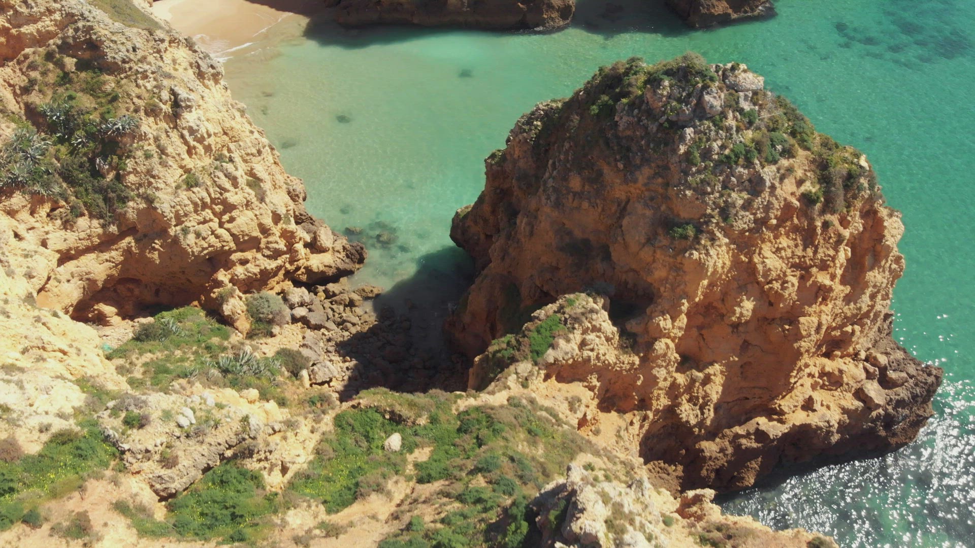 Fly over limestone cliffs, rock formations of different shapes and sizes against blue ocean water