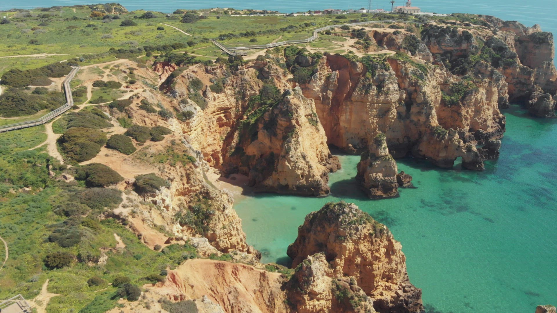 Distant view of Ponta da Piedade Lighthouse overlooking the Atlantic Ocean and eroded cliffs, Lagos,