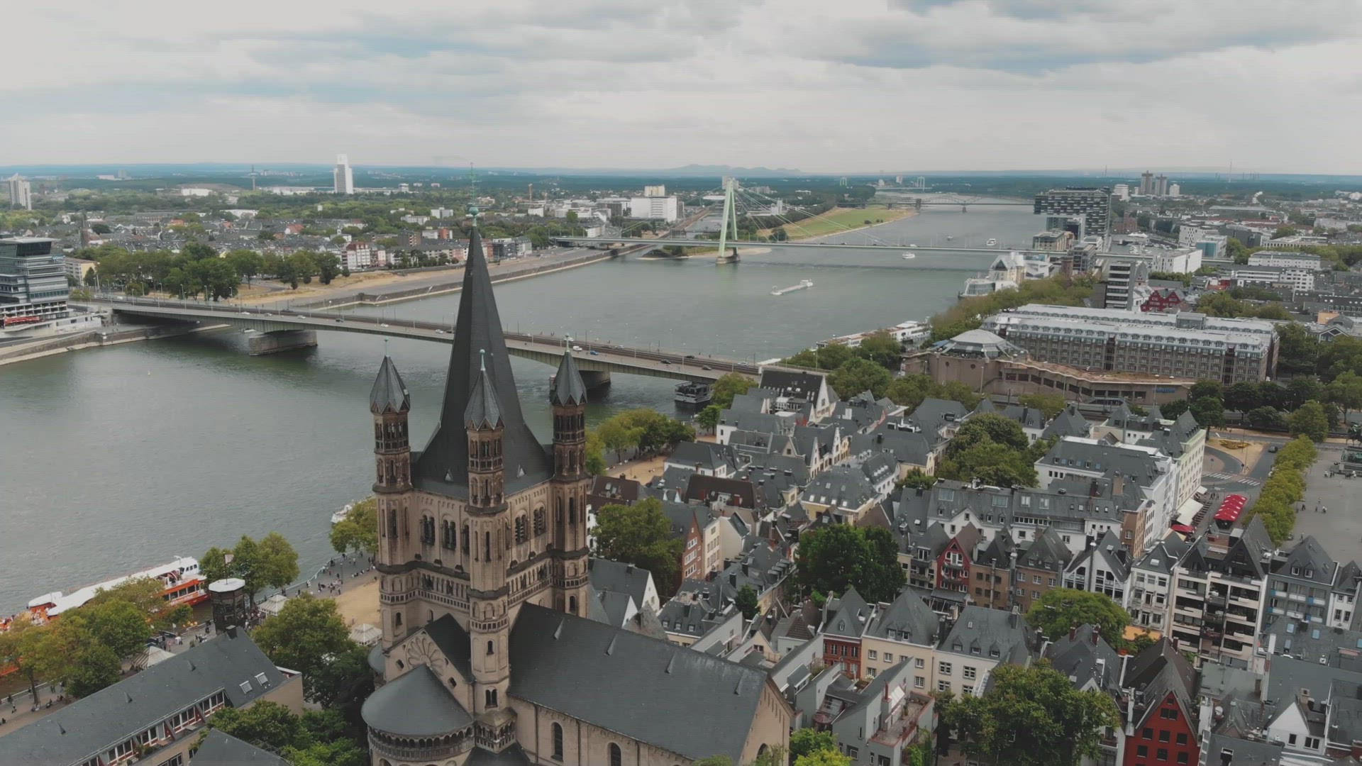 4k footage flying over the historical Great Saint Martin Church towards the Deutz Suspension Bridge 