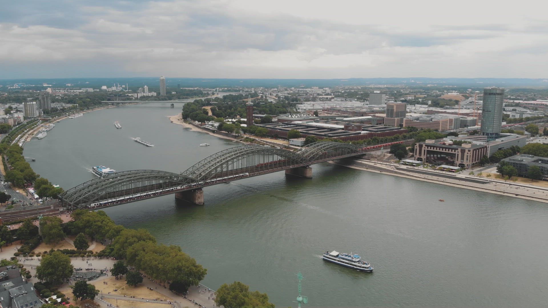 Aerial slow left pan of the Rhine River and cityscape of Cologne, Germany.	