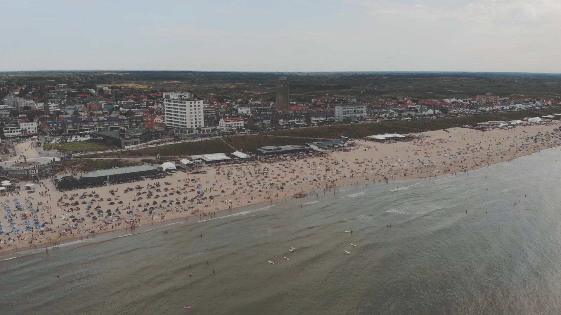 Footage of crowded beaches along the coastline of the city Zandoort, Netherlands of the North Sea.	