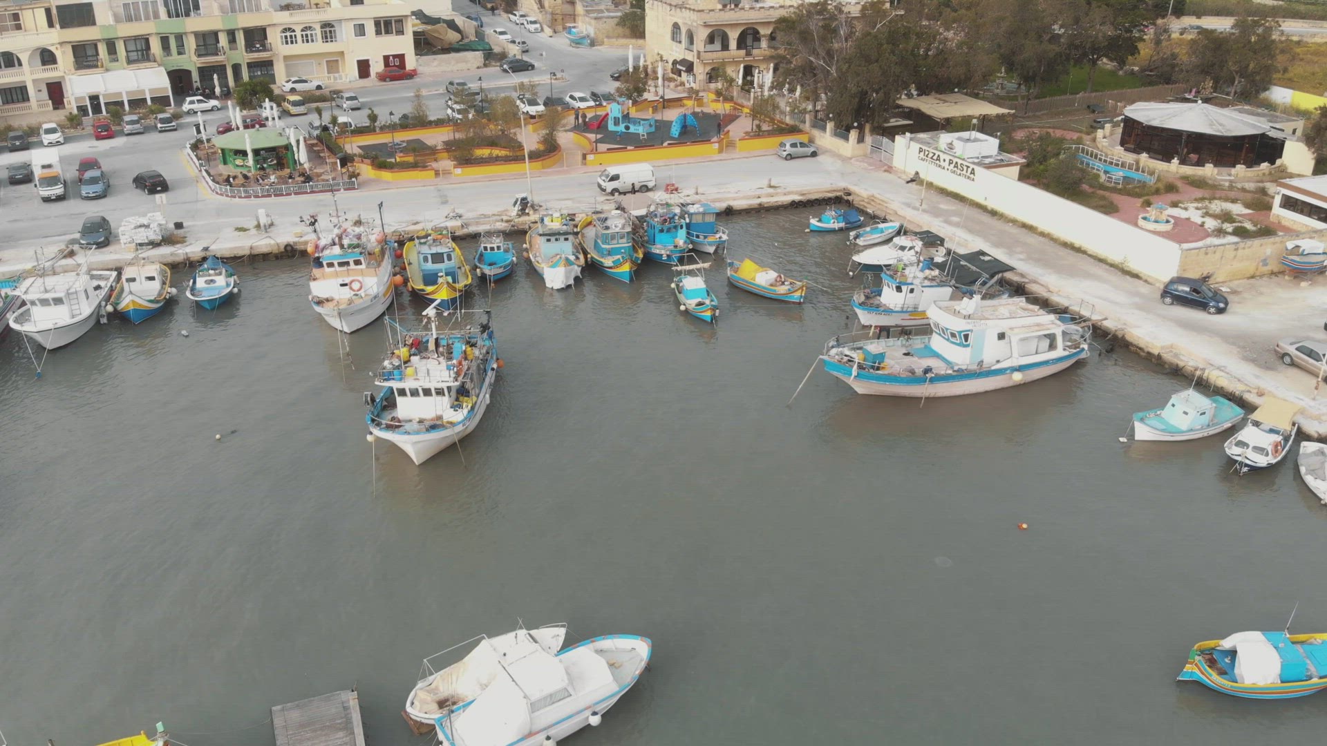 Aerial Push In Shot of Bobbing Fishing Boats In Marsaxlokk Malta	