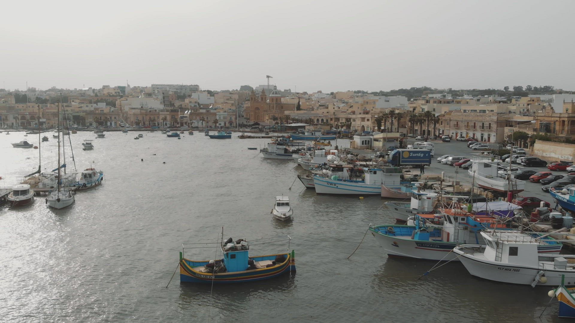 Aerial Push In Shot Over Fishing Boats in Marsaxlokk Malta	