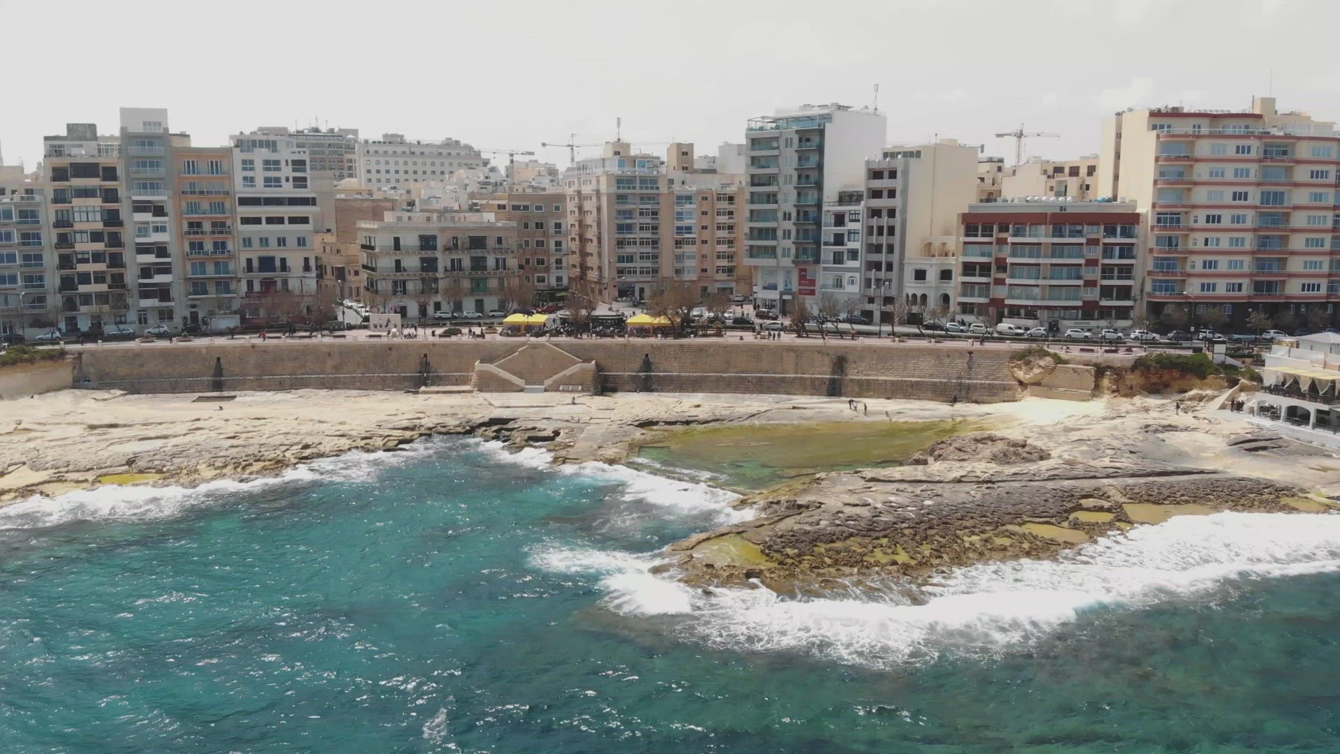 A pull back reveal aerial 4k drone cityscape footage of the resort town of Sliema, Malta as seen fro