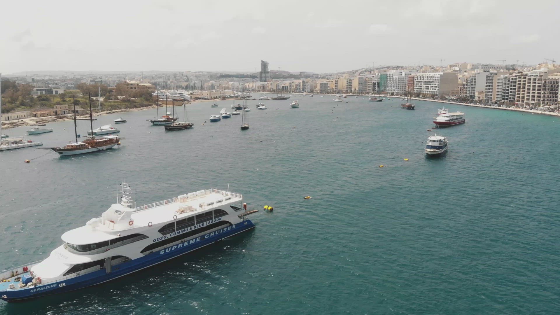 4k aerial drone footage of a ship and boat filled harbor of the Mediterranean tourist resort town of