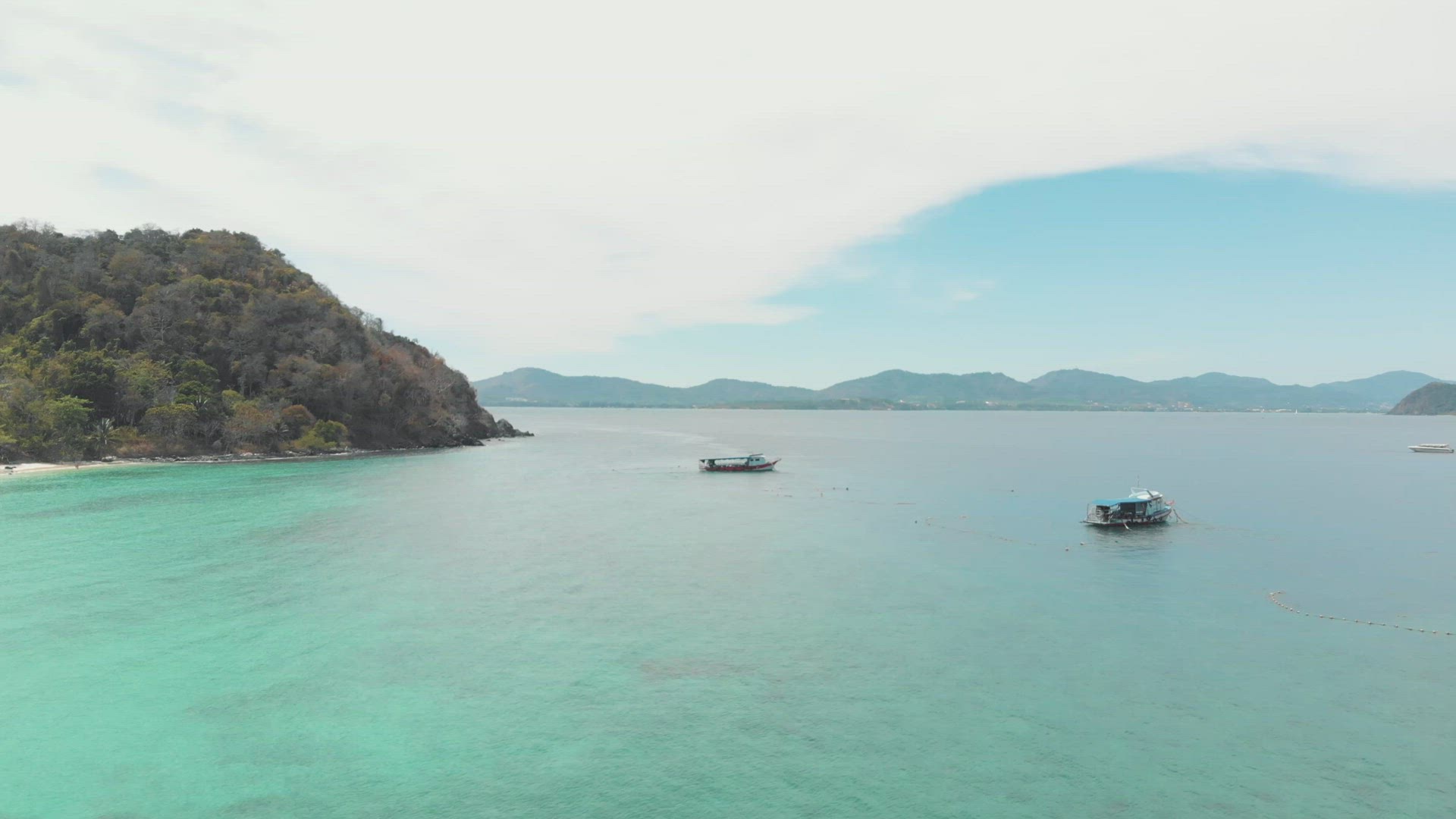 Clean crystal waters of Phuket against mountains. Aerial shot