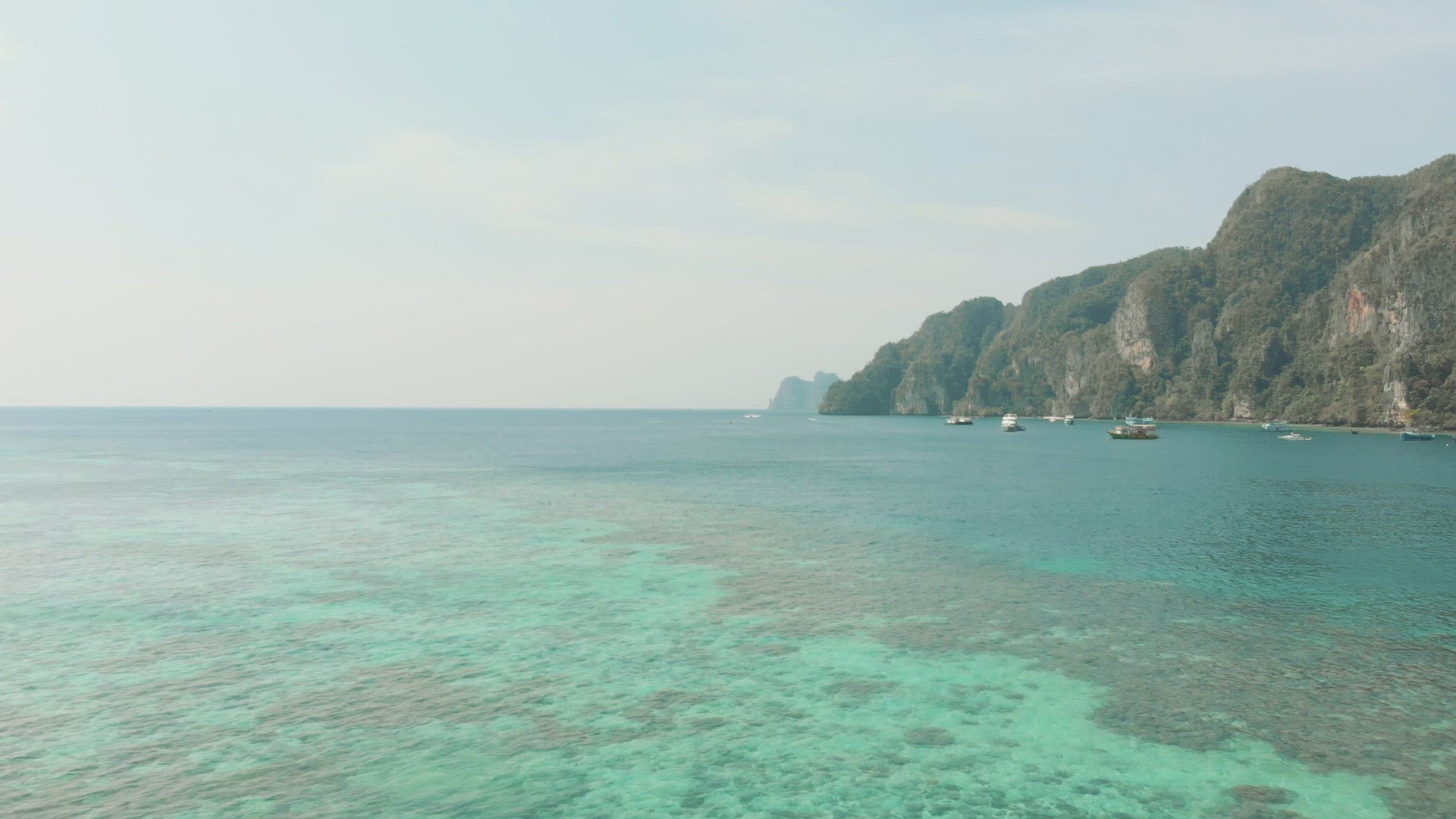 Shallow warm Emerald green sea covering the vastness of Ko Phi Phi Don Island Coast in Thailand - Ae