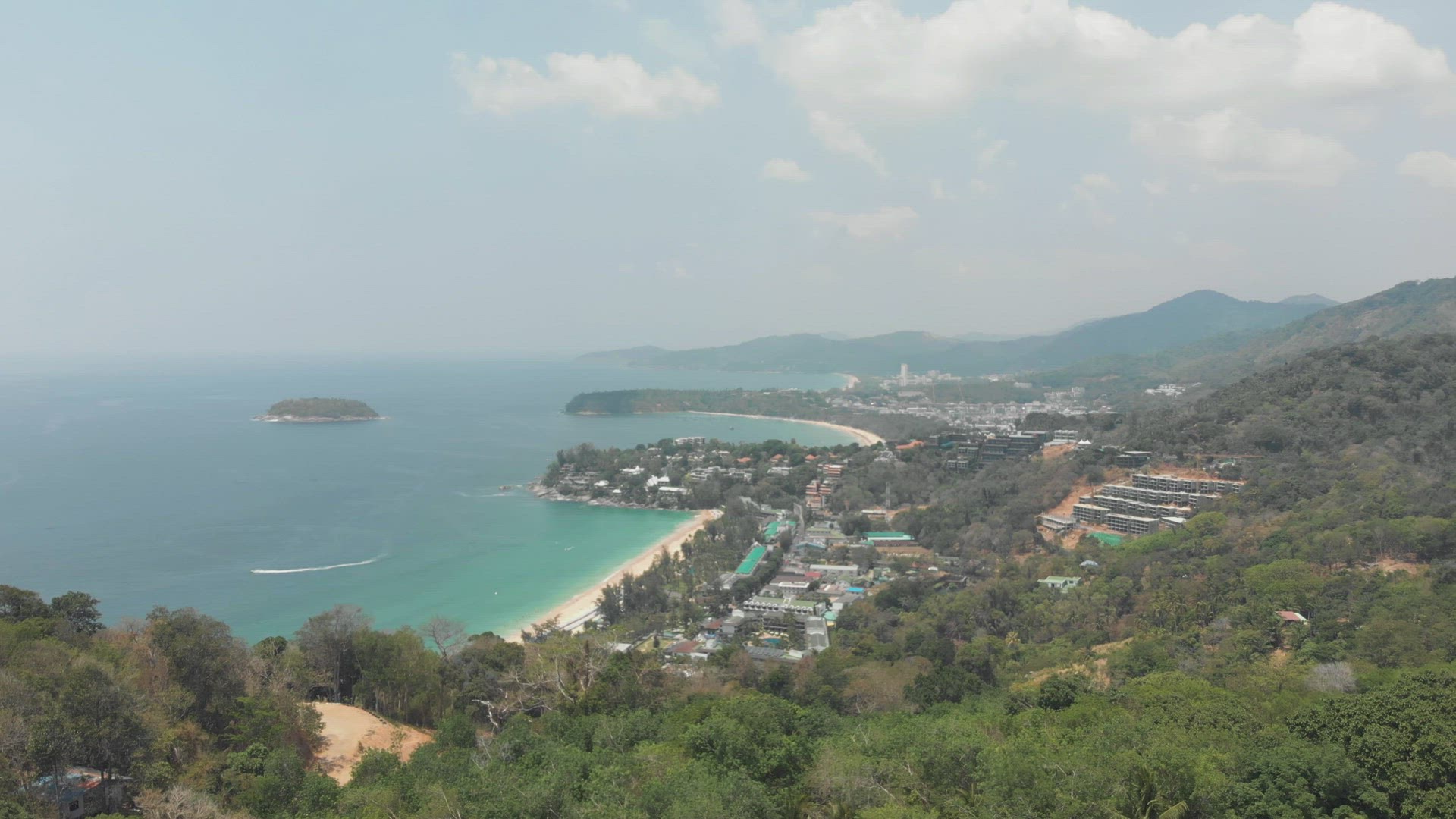 Establishing shot of Phuket. Forest embracing  tropical beach by Andaman sea