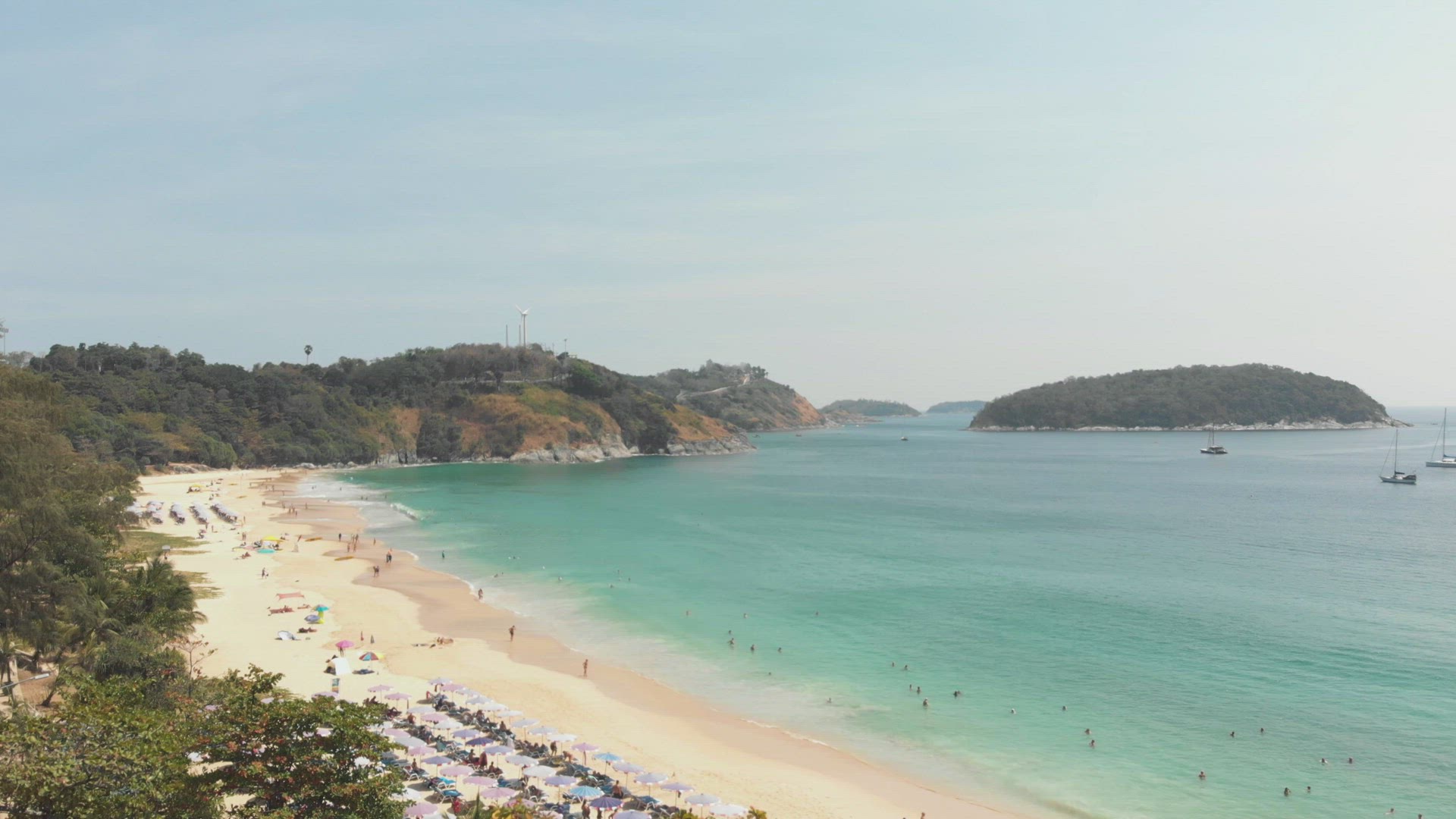 Reveal of tranquil Nai Harn bay in southern Phuket, Thailand - Aerial wide Fly-over shot