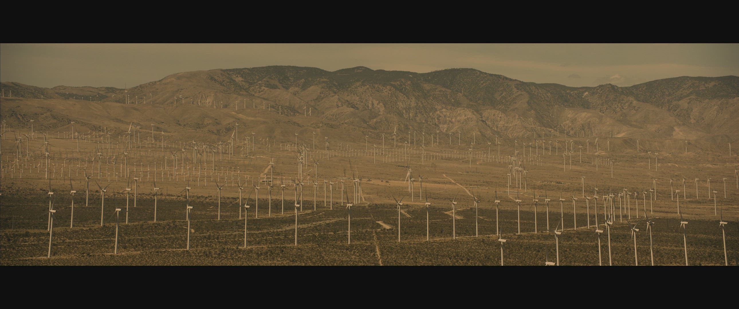 Wide aerial shot over wind turbine farm