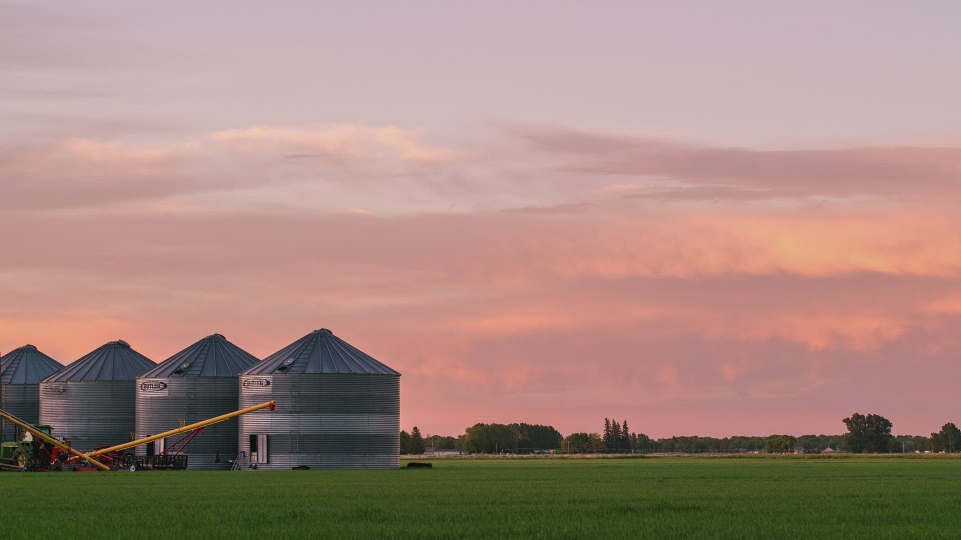 Colorful sunset over farm fields in Idaho looking past grain bins