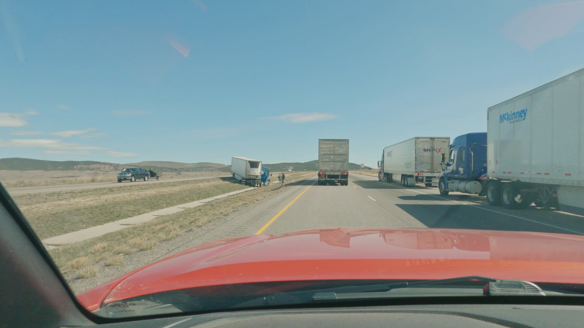 Semi truck jackknifed in the center median on the freeway leaking fuel