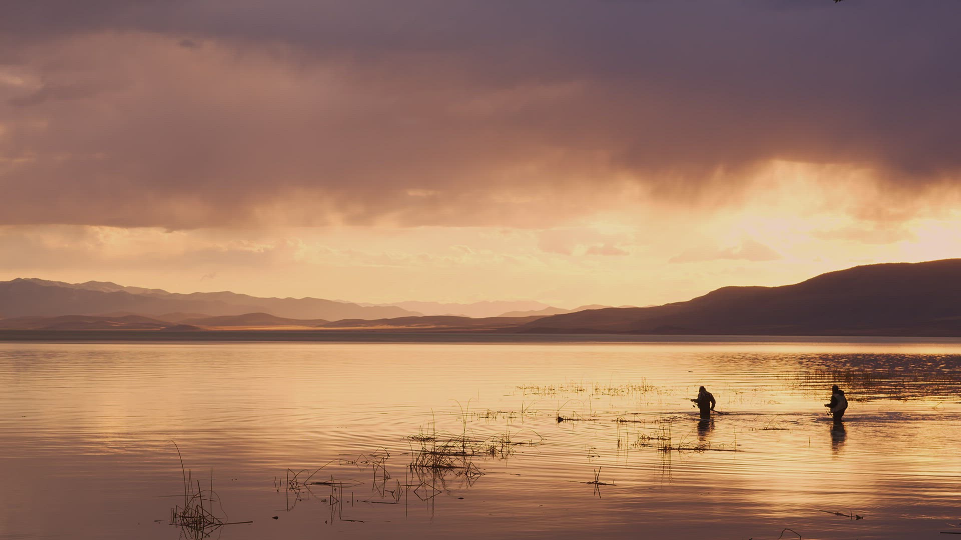 Fishermen wading through the water to fish in Utah Lake at sunset