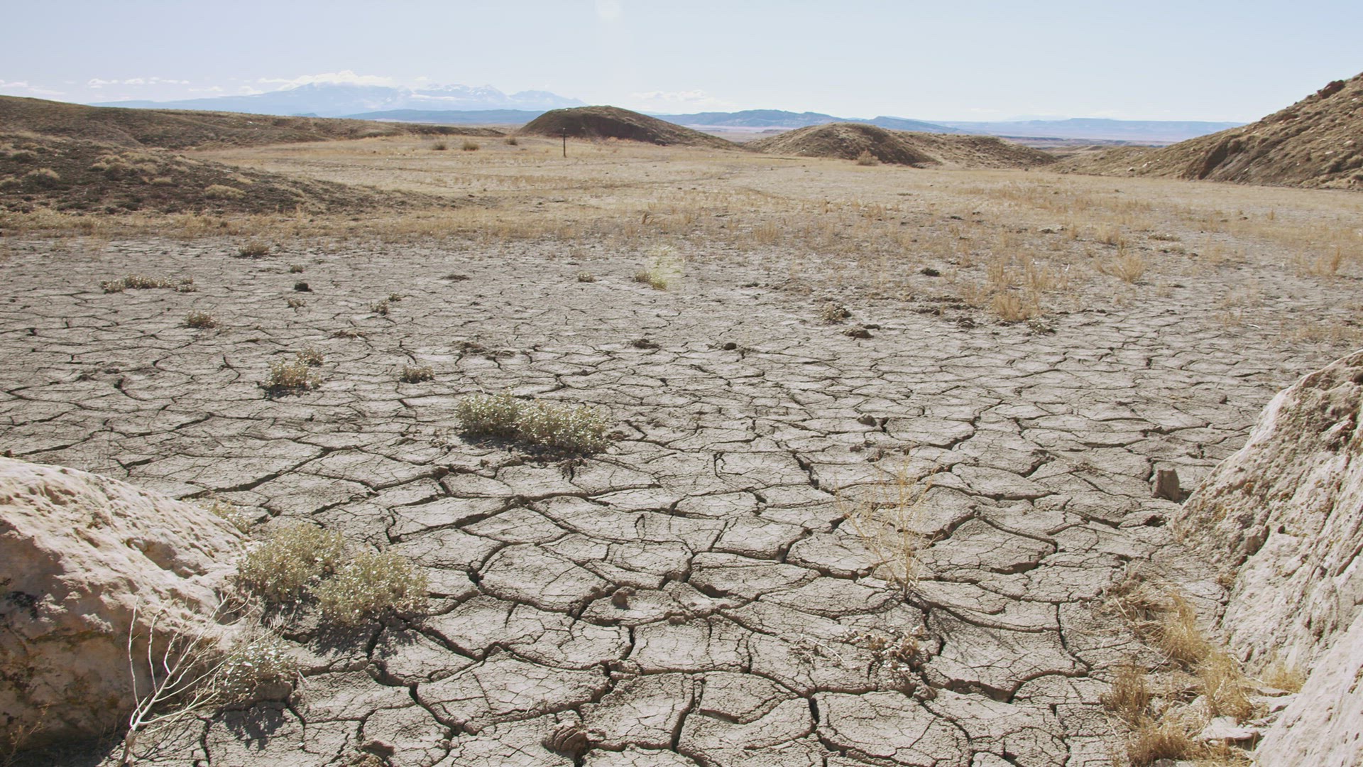 Panning over dry desert landscape with cracks in the soil