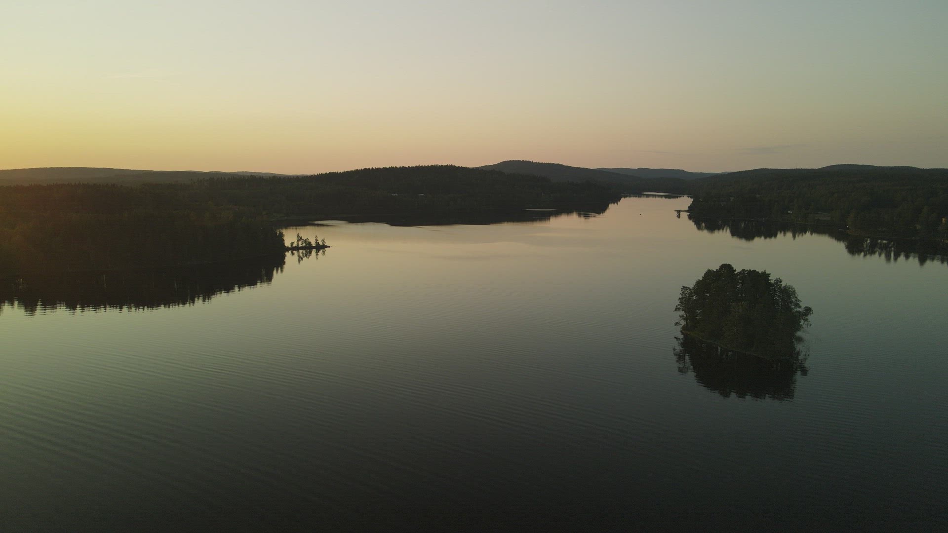 drone shot - pov golden hour -  flying over mirror lake with islets