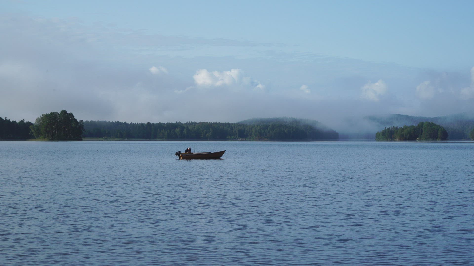 man fishing in lake - standing in small boat
