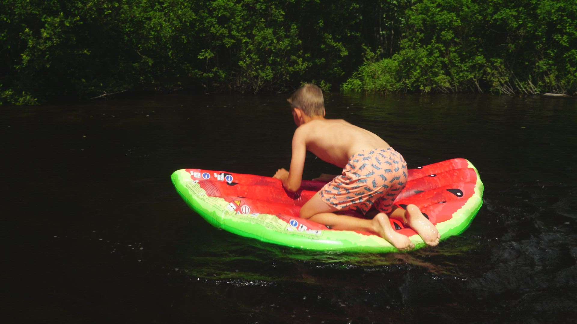 boy balances on air mattress - trying to stand