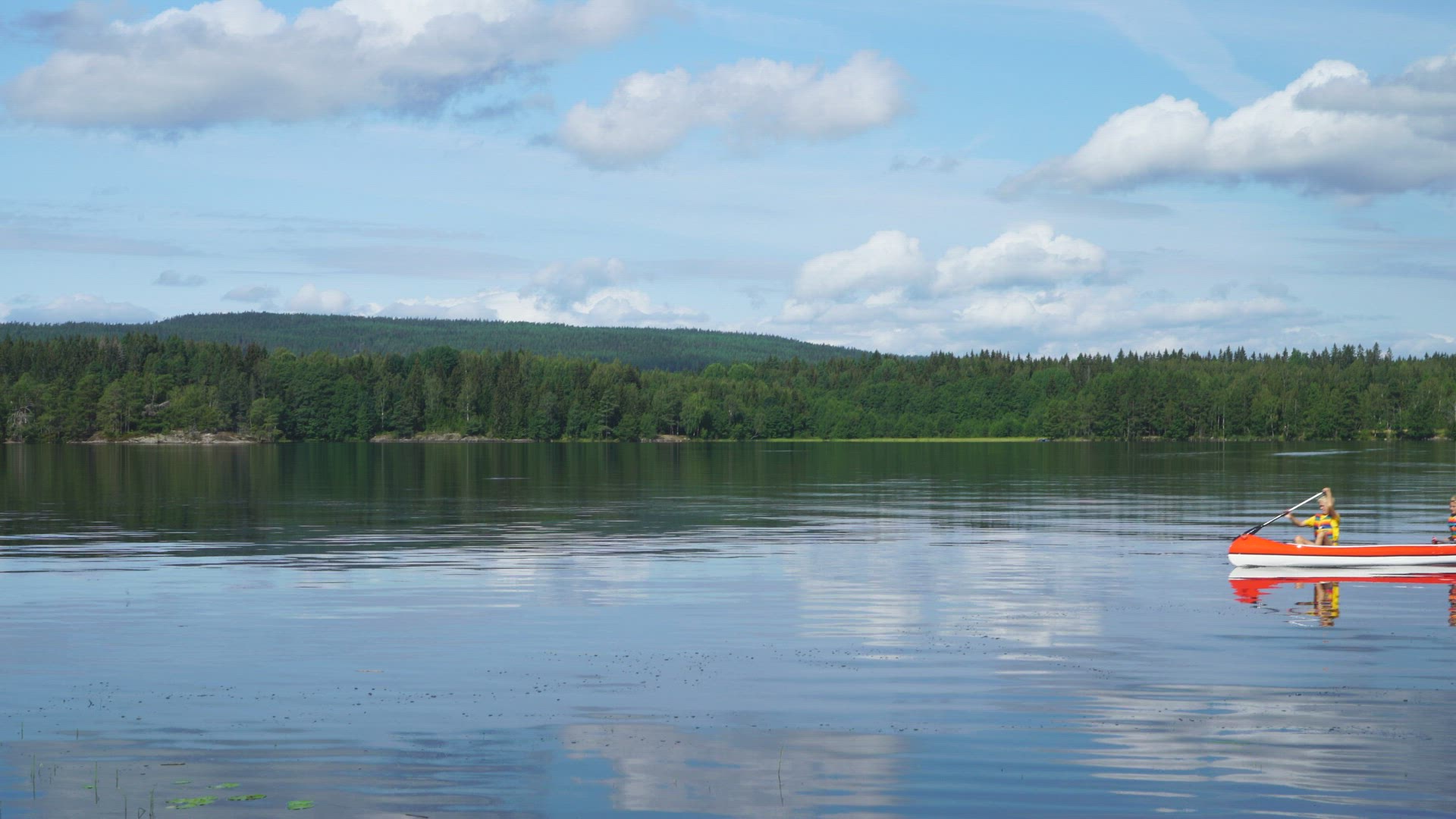 two boys paddling in canoe on mirror lake