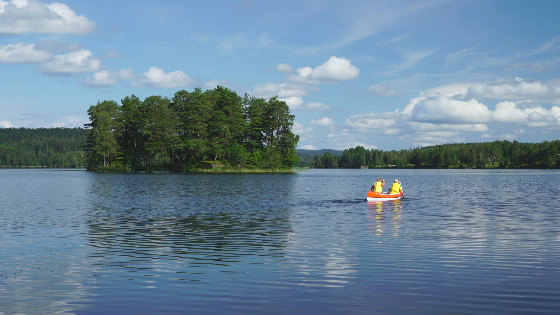 two boys paddling canoe on lake - paddling away from camera