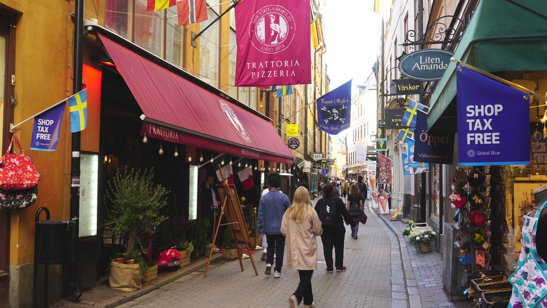people walking on narrow touristic street in Old Town in Stockholm