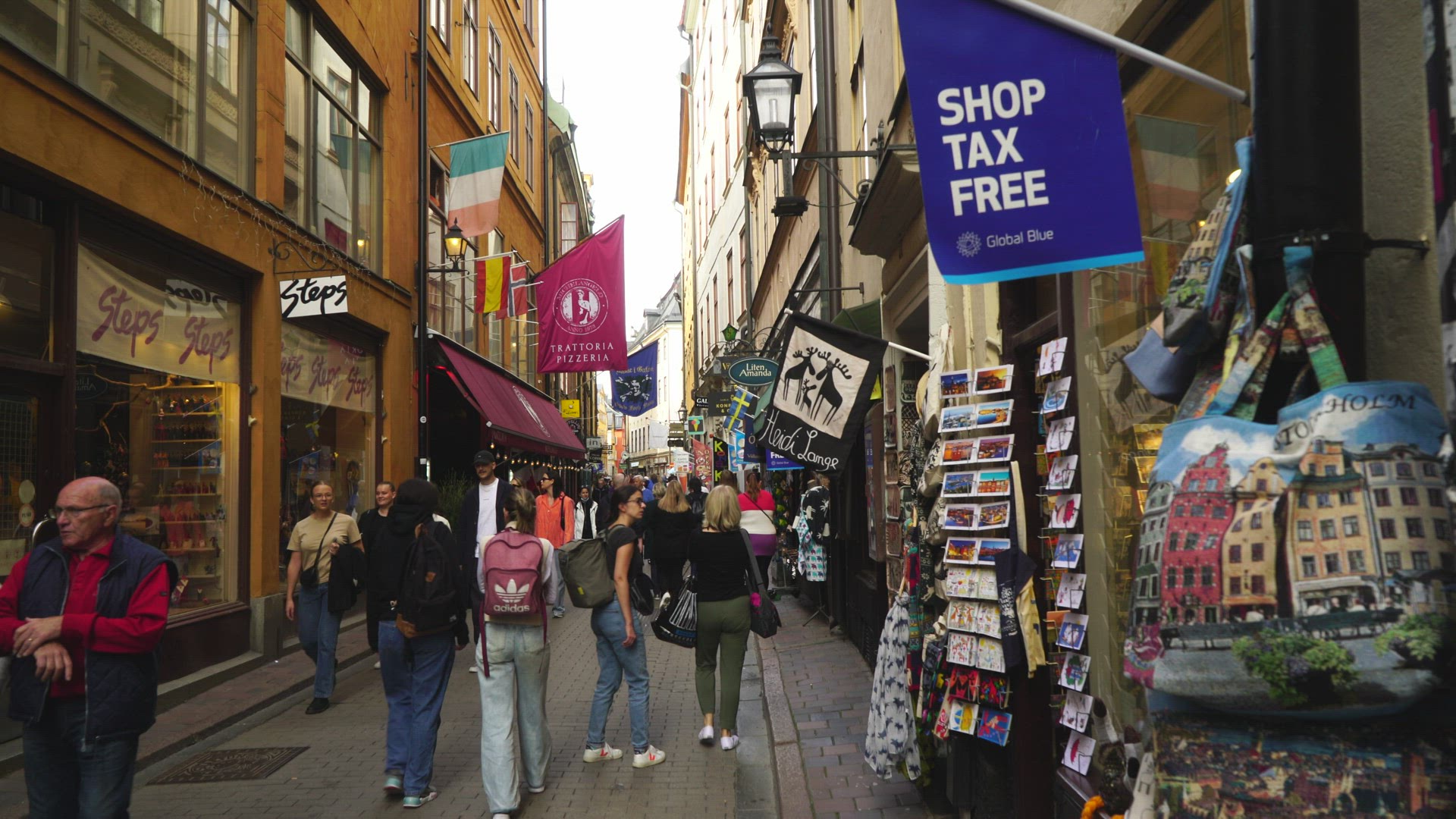 people walking on narrow touristic street in old town in Stockholm