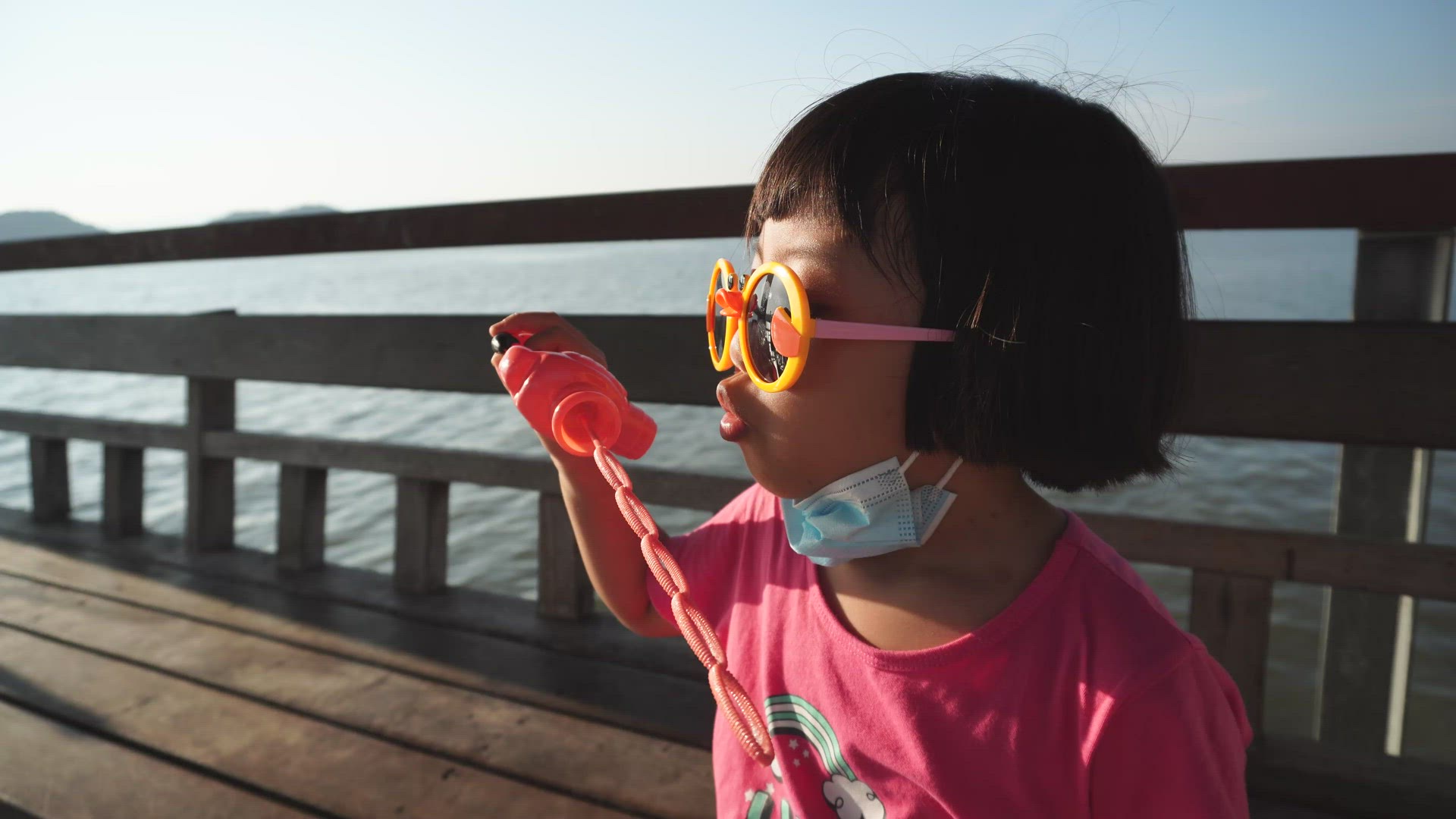 Chinese kid with mask and sunglasses blow the bubble