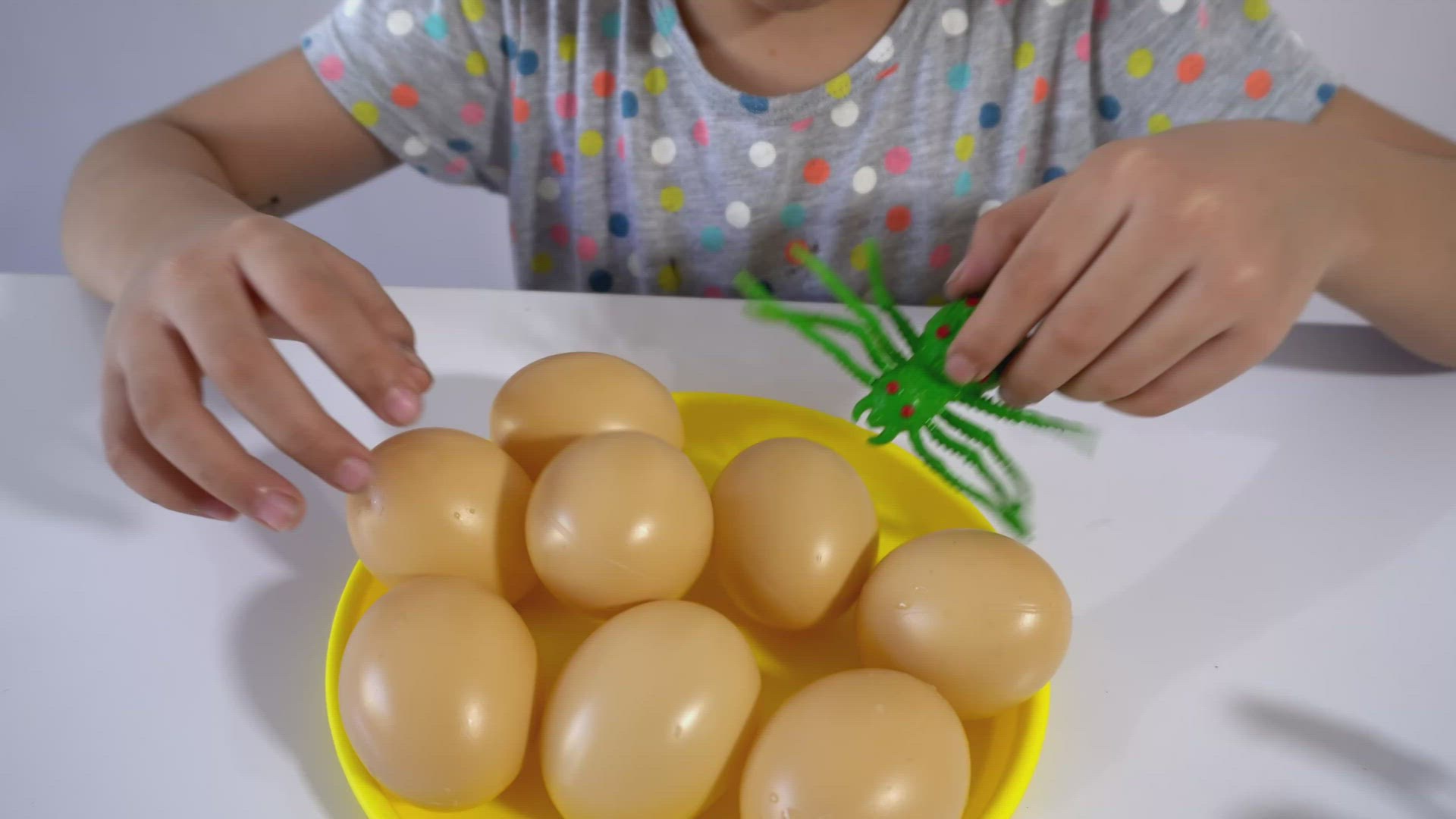 Little kid hold the green spider toy