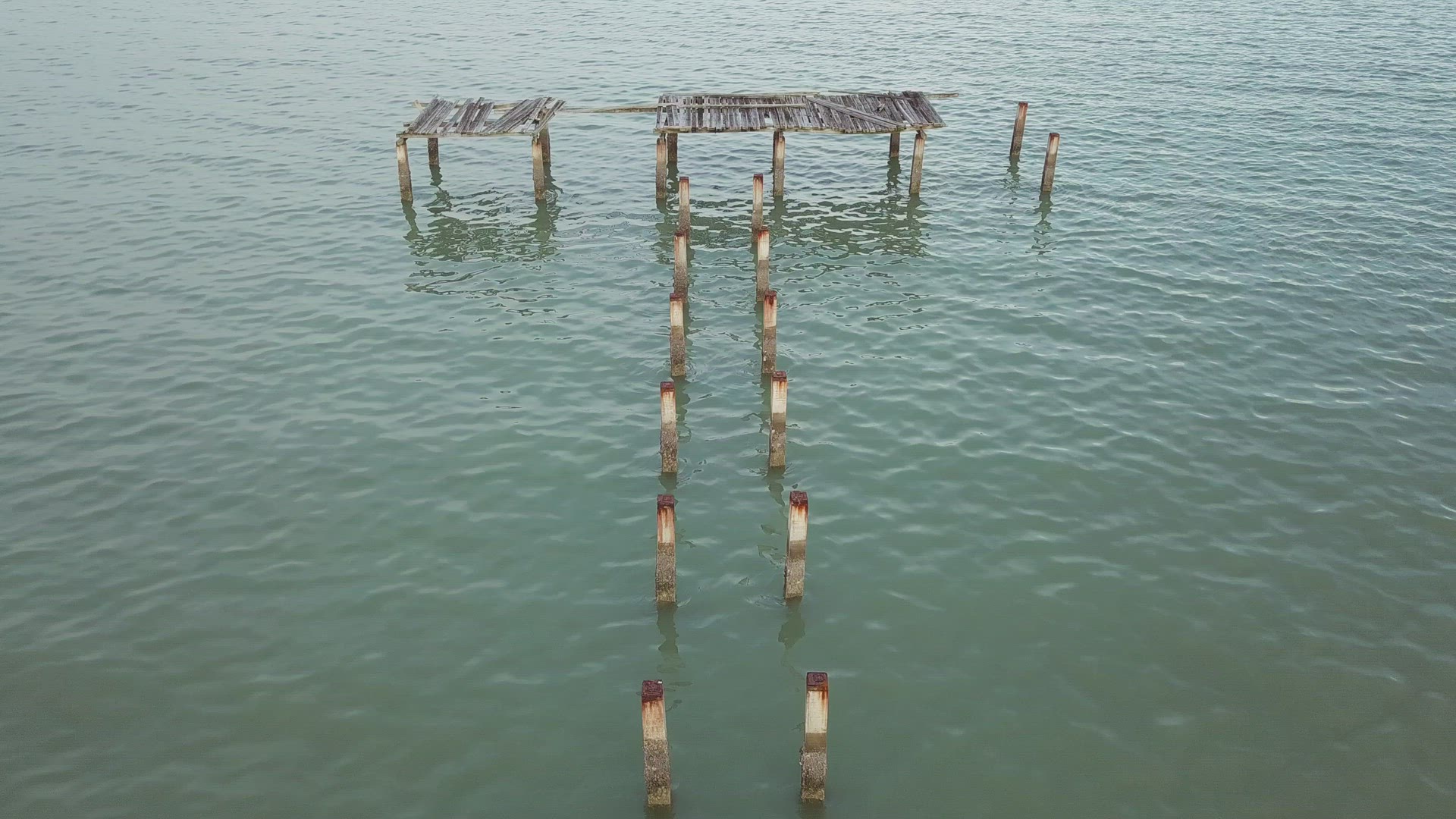Move toward broken wooden bridge on sea. 