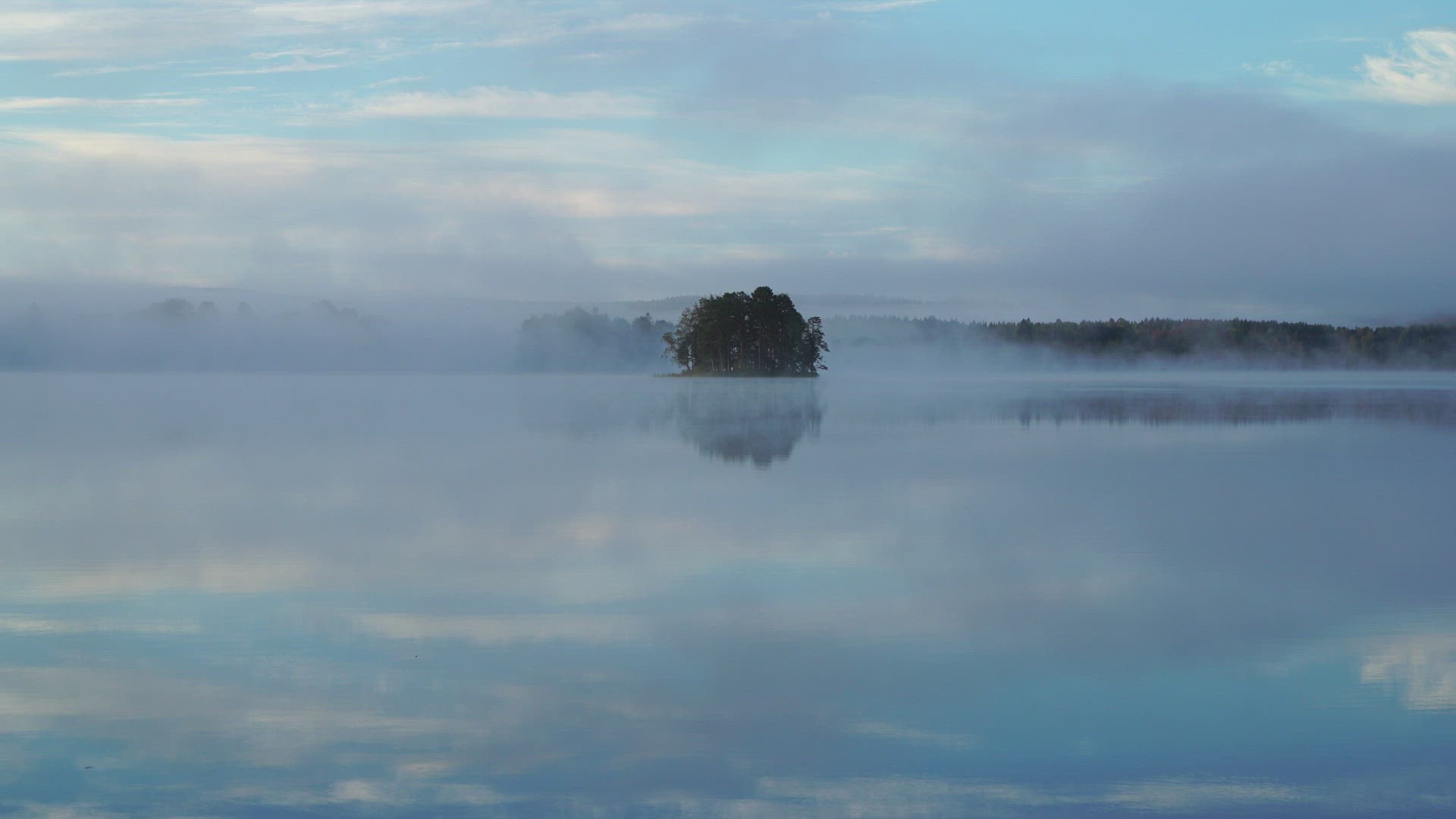 view over mirror lake with morning mist - fog and islet