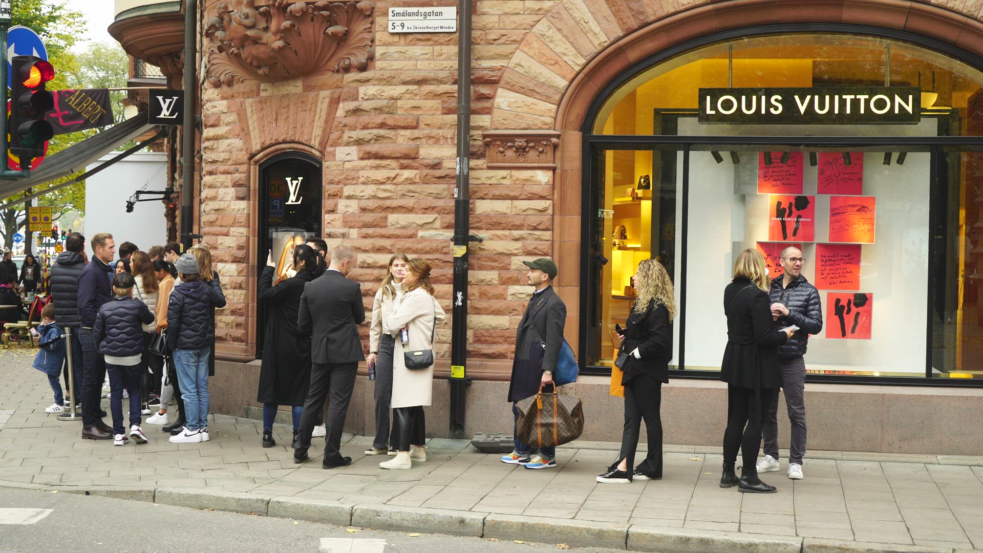 people waiting queuing outside Louis Vitton shop in central Stockholm