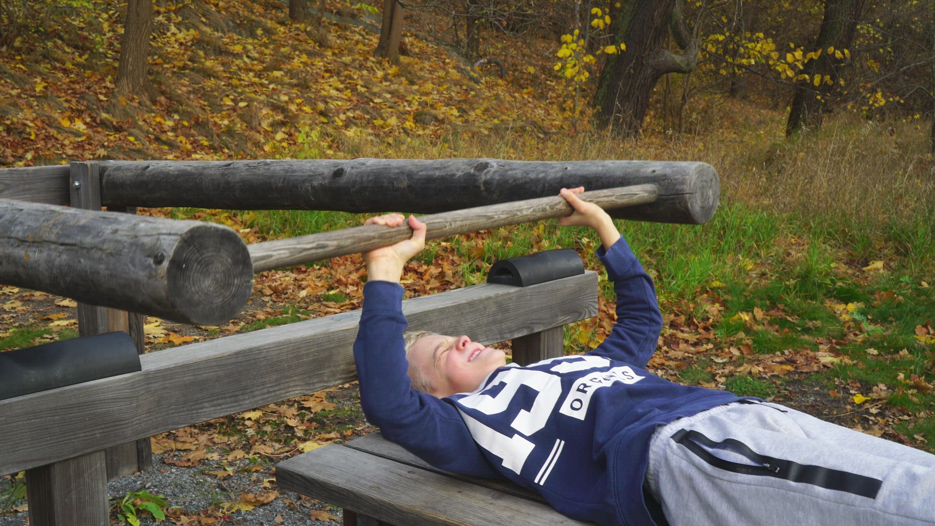 boy lifting weight in outdoor gym - struggling