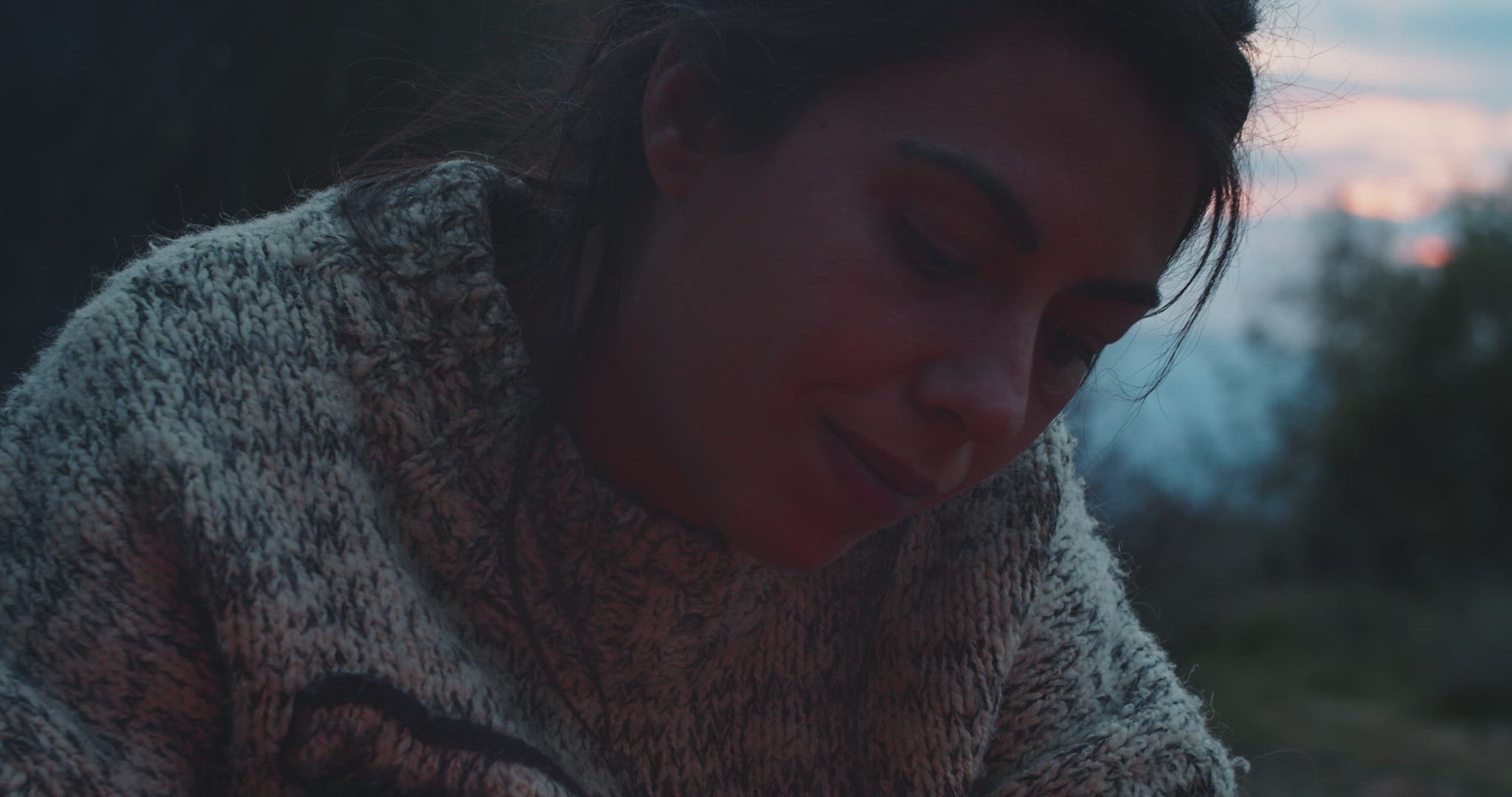 Woman lights bonfire at sunset