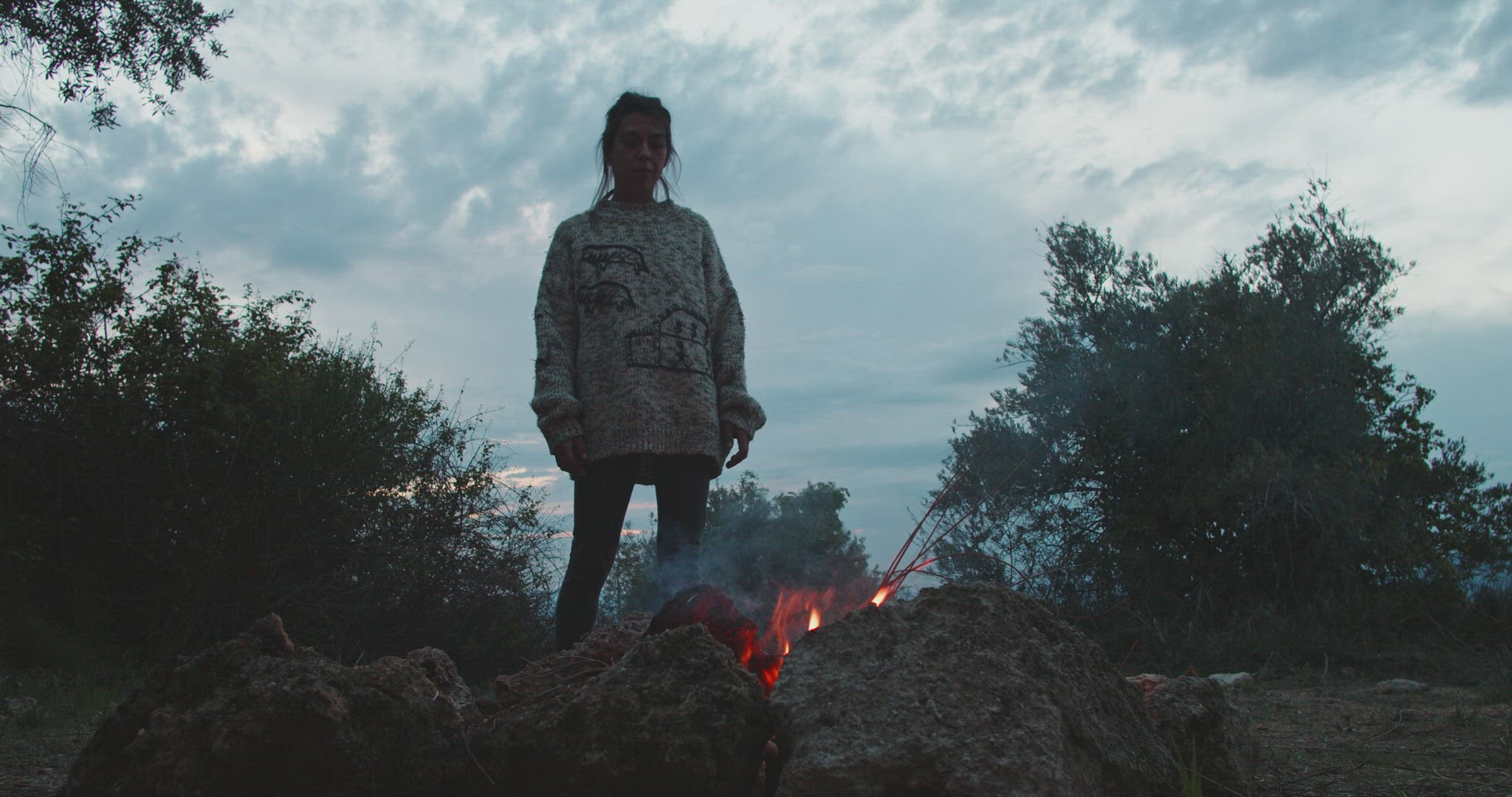 Woman standing in front of a bonfire