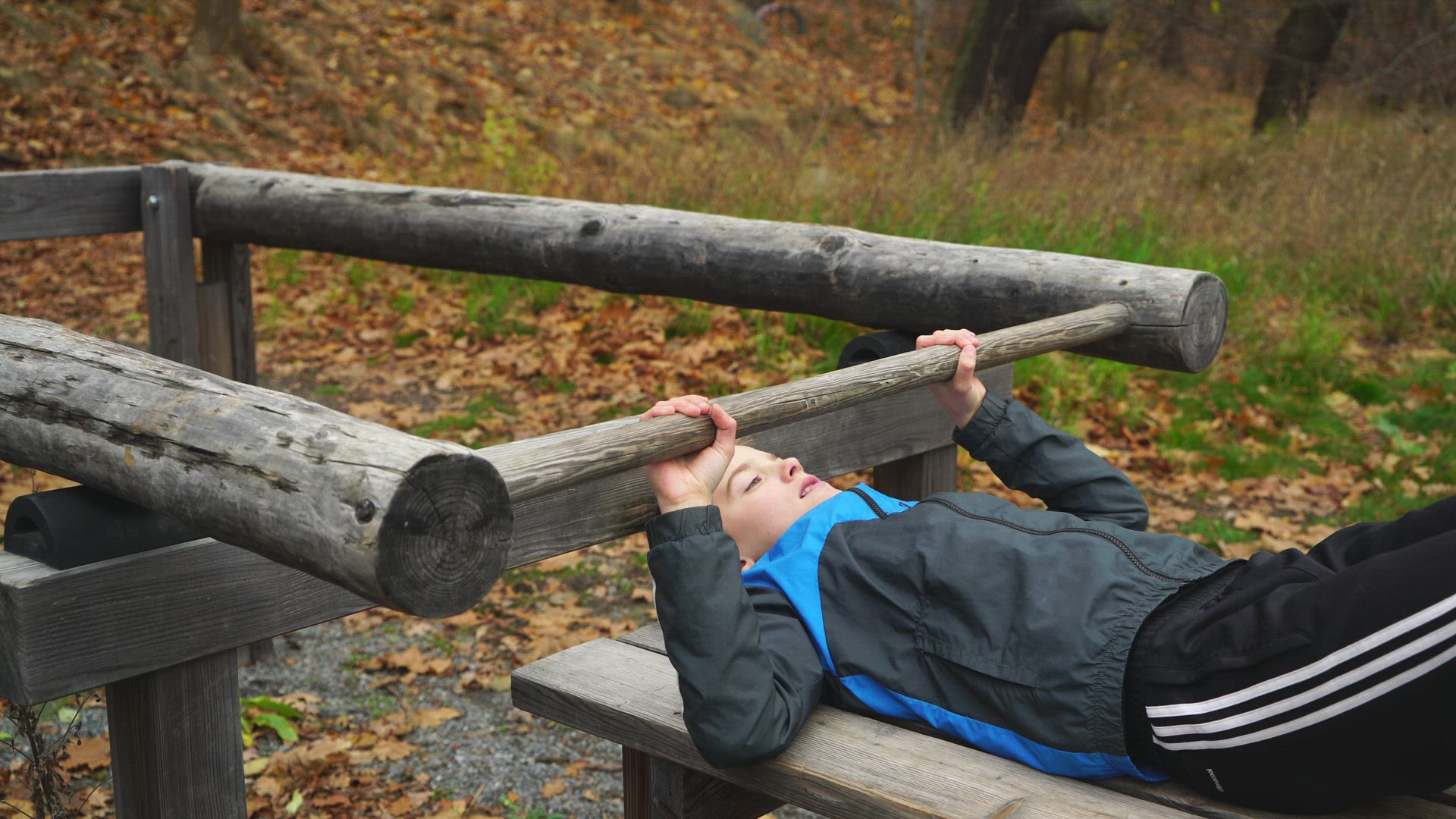 boy lifting weights at outdoor gym