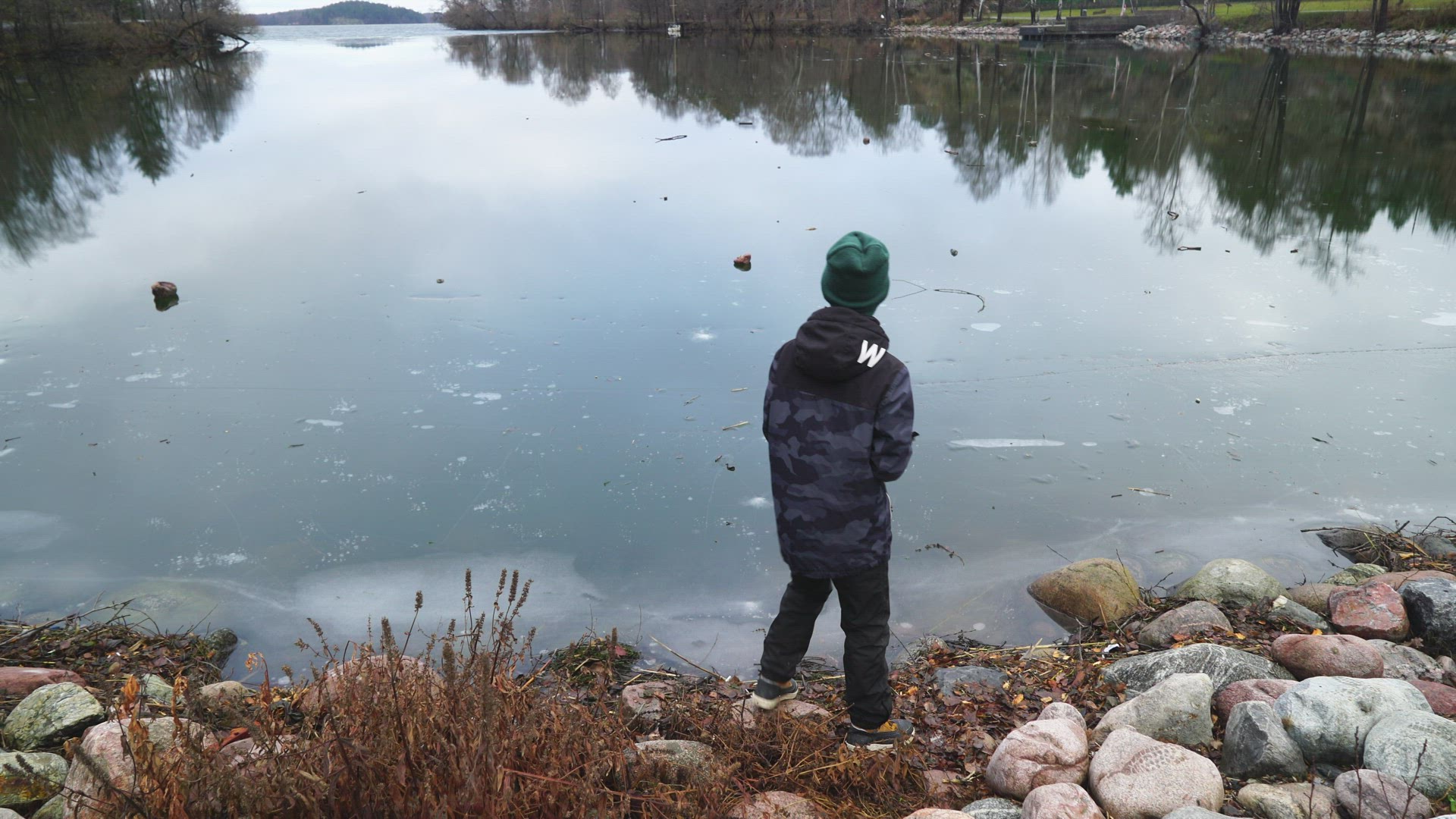 boy throws stone  - stone bounces on thin ice