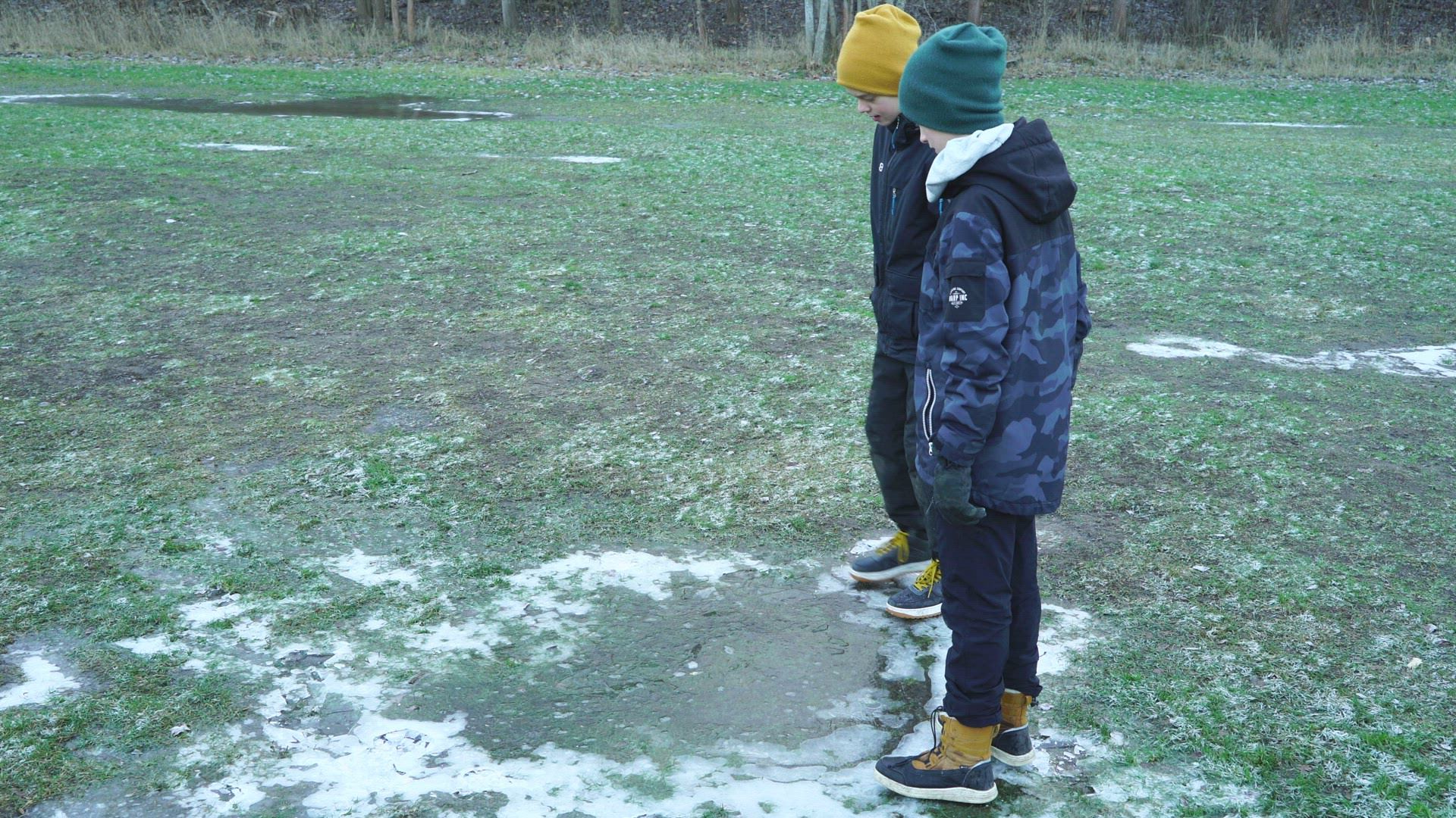 two boys jumping on thin ice - one slipping and falling
