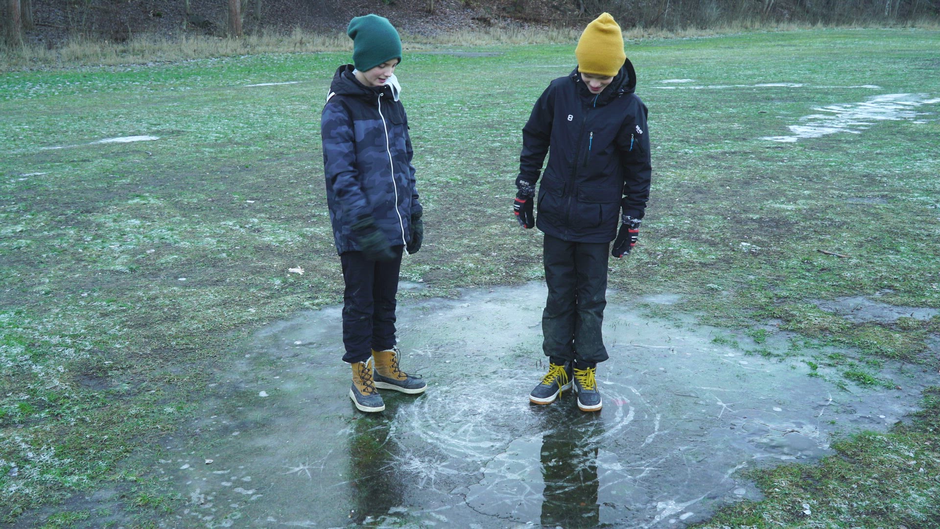 two boys jumping on ice - ice breaking