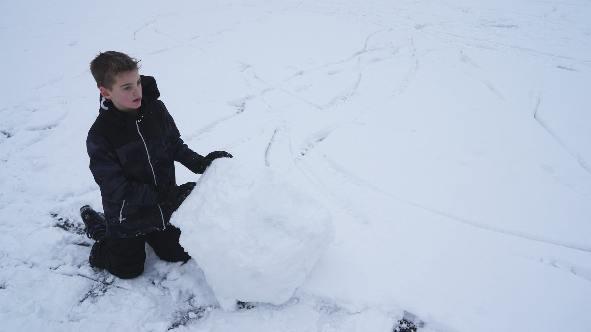 boy rolling snowball