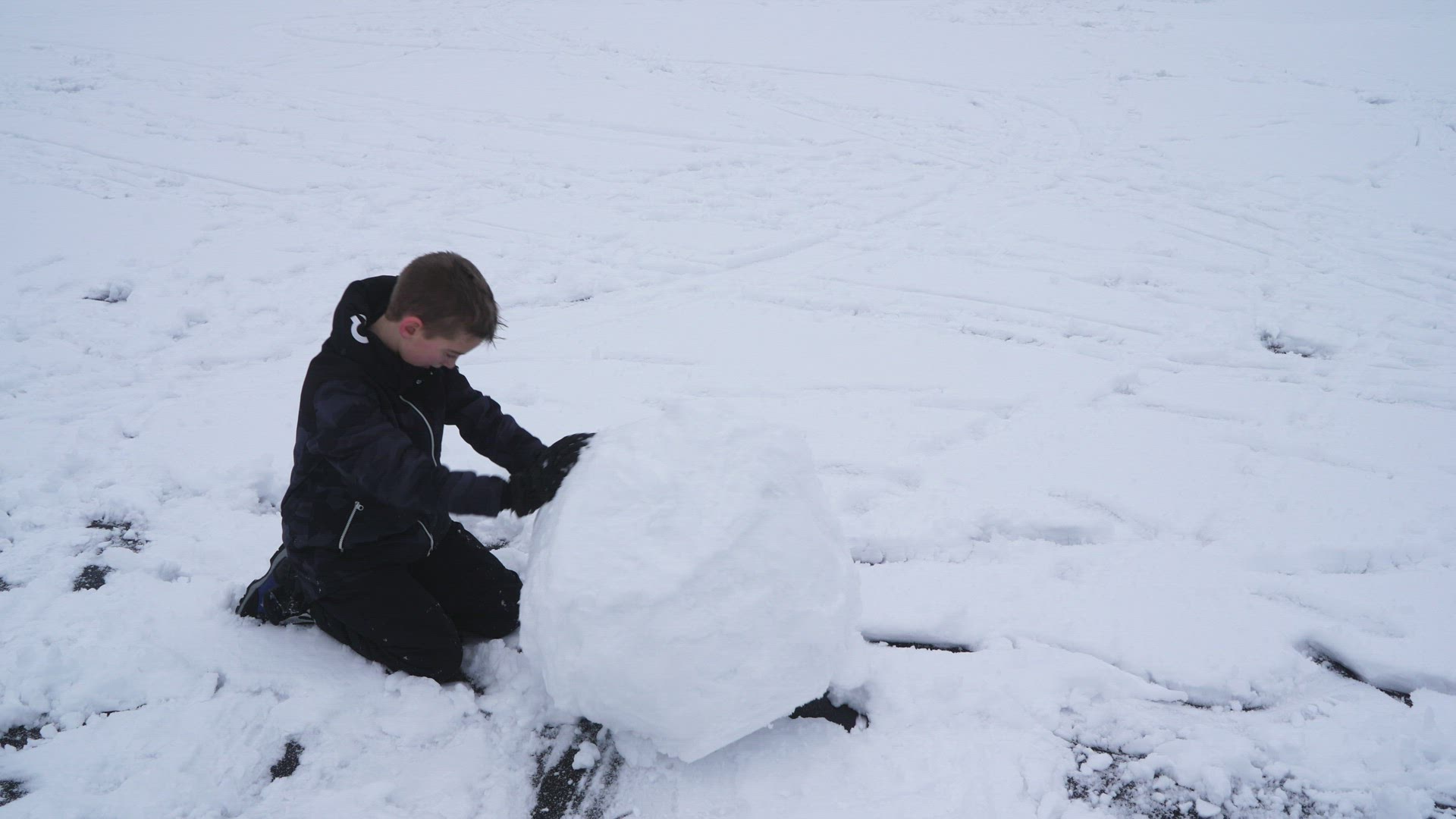 boy rolling snowball