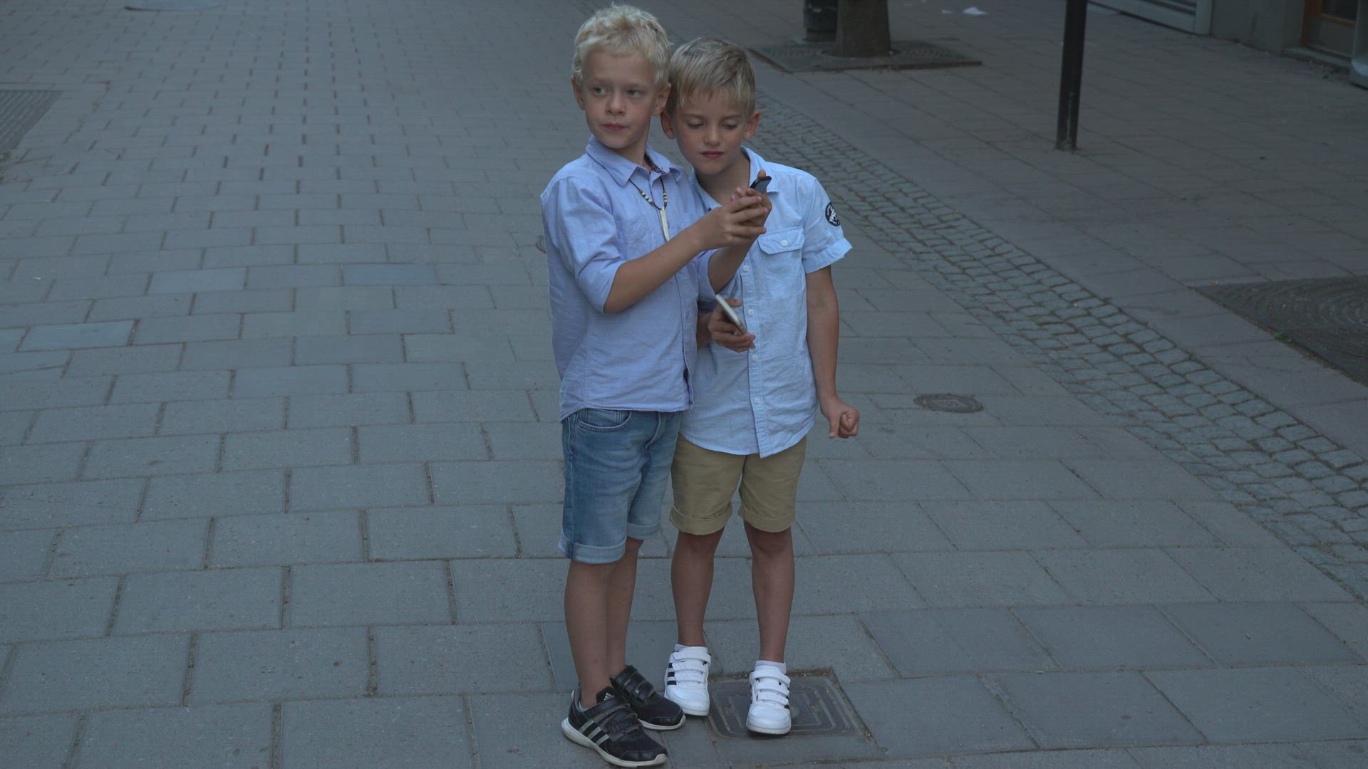 boys standing in street playing pokemon go