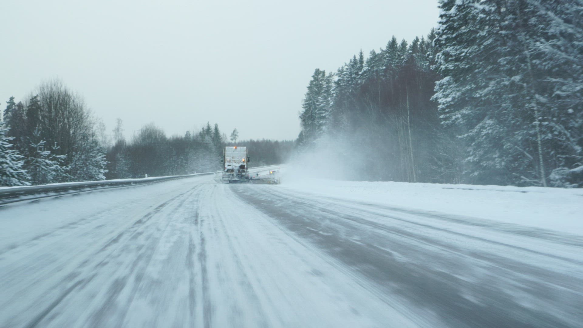 pov from car - driving by plow truck on wintry road