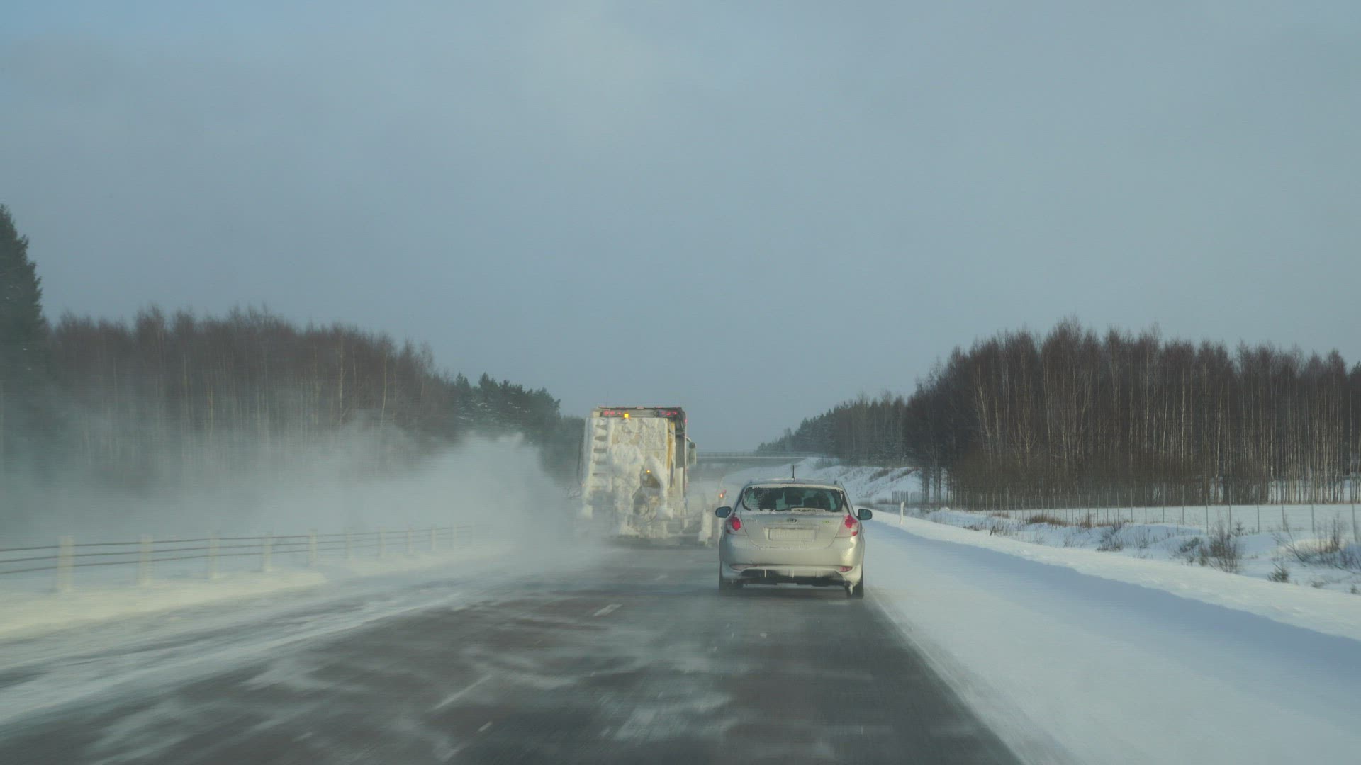 pov from car - drivers view - traffic on wintry road - cars drives by snow truck