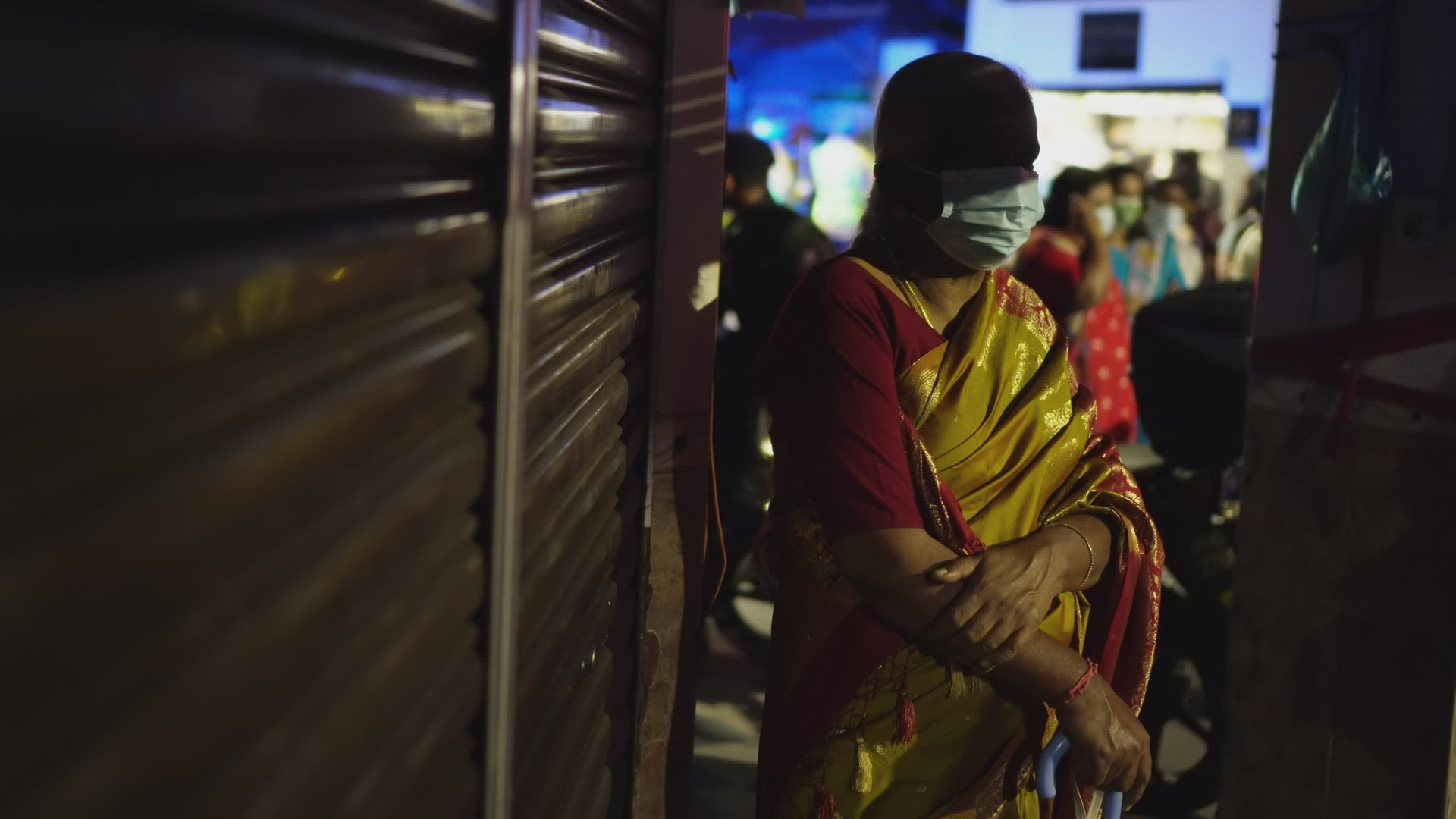An lonely wear face mask Indian woman stand away from crowd