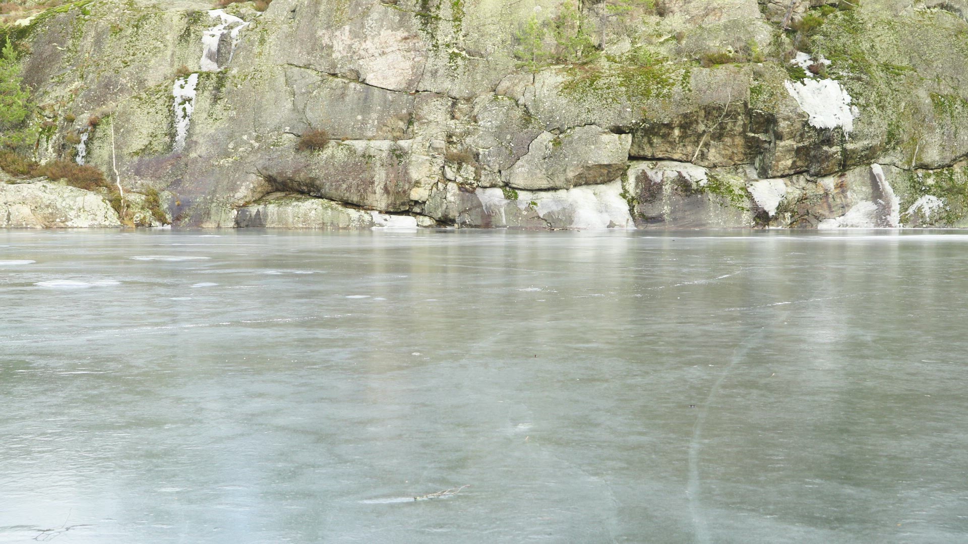 two boy walking and running over frozen ice on lake