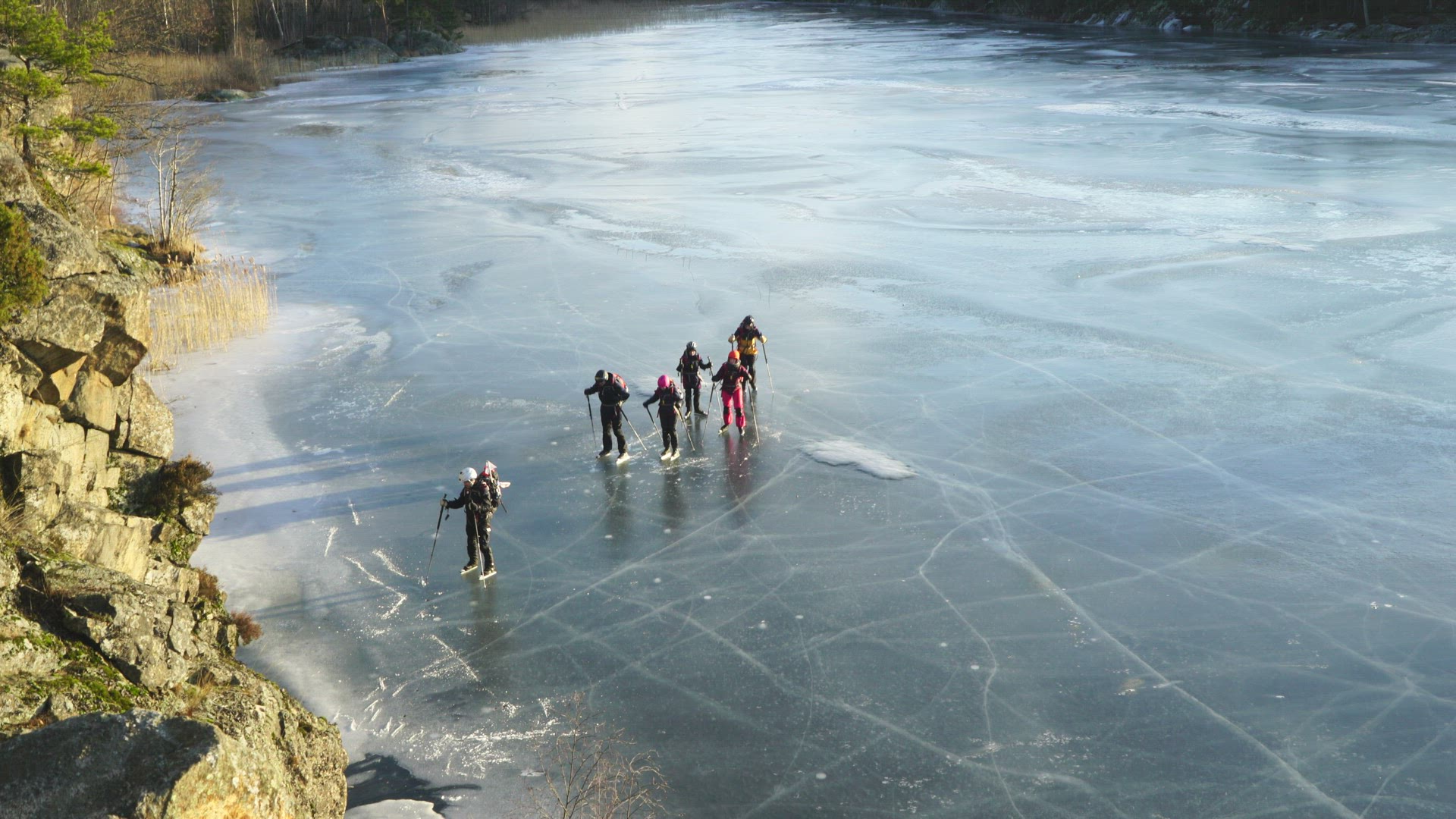 group of people iceskating on frozen lake