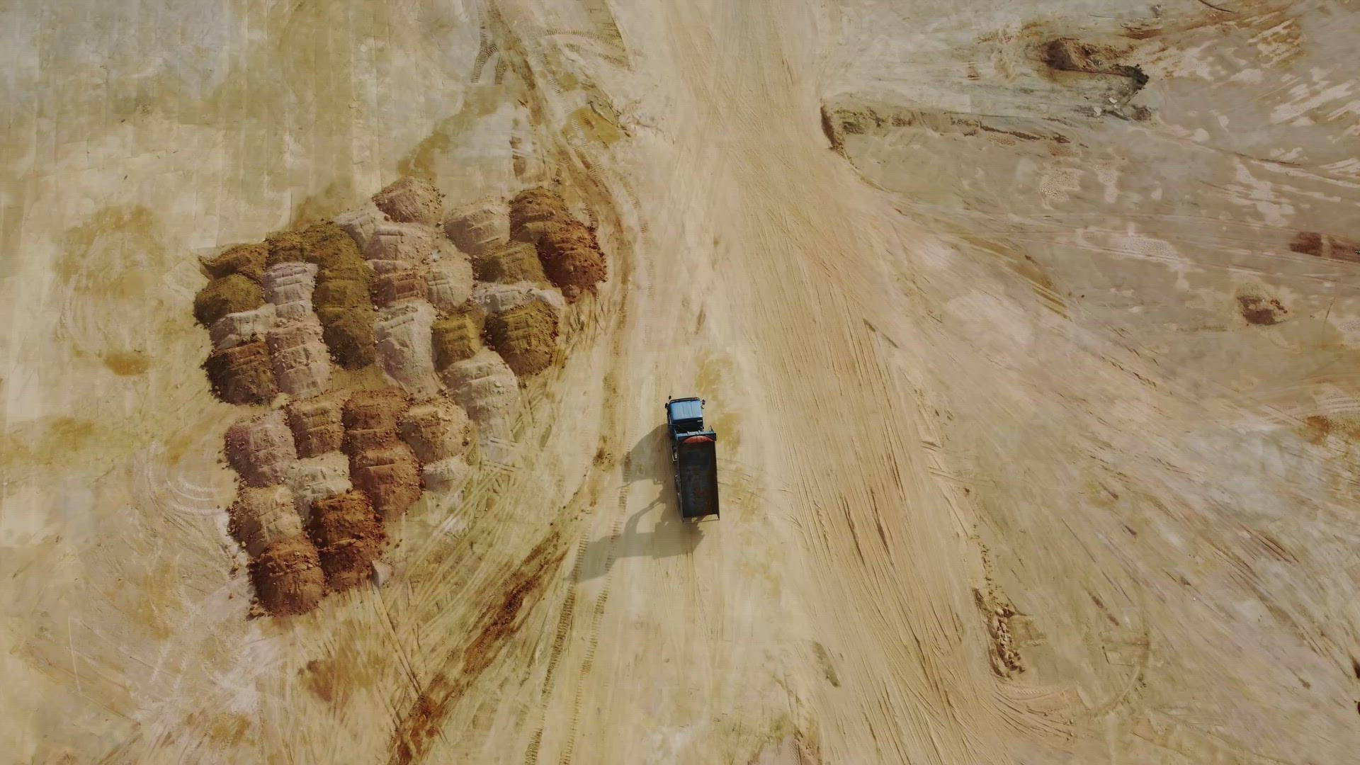 Aerial Aerial view dump truck move at yellow soil