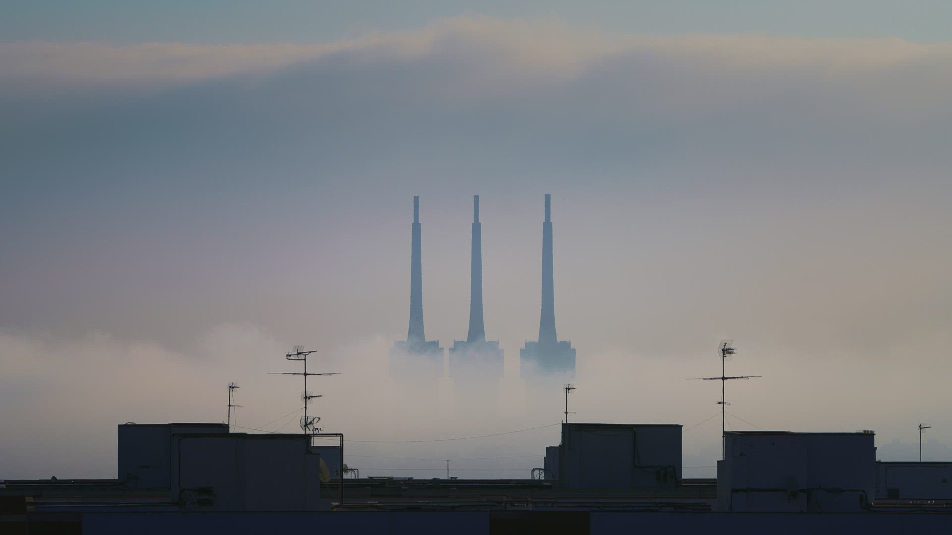 Three-chimney from a thermal power plant covered by fog