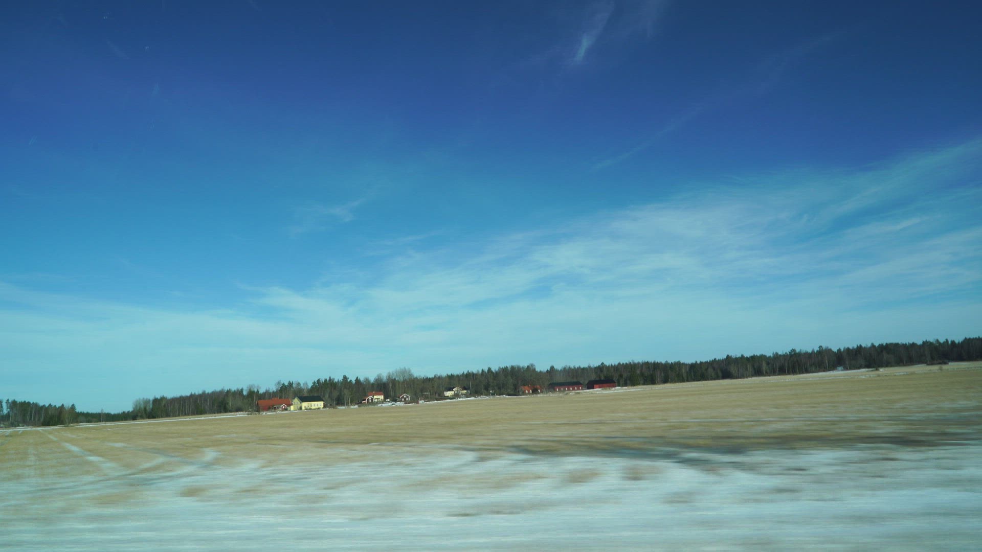pov side window - car travelling past frozen snowy fields in sweden